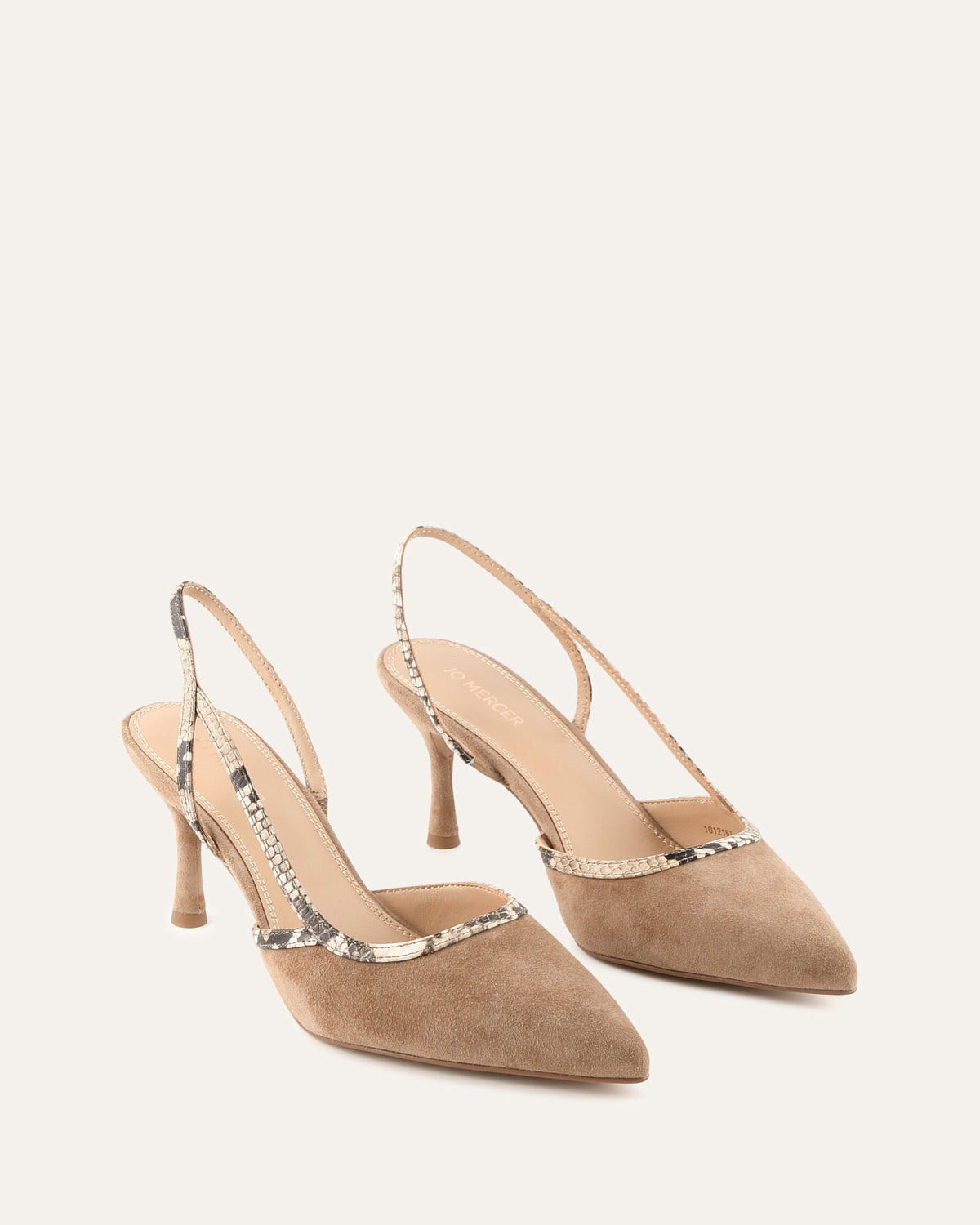 Pair of beige high-heeled shoes with decorative straps on a light background