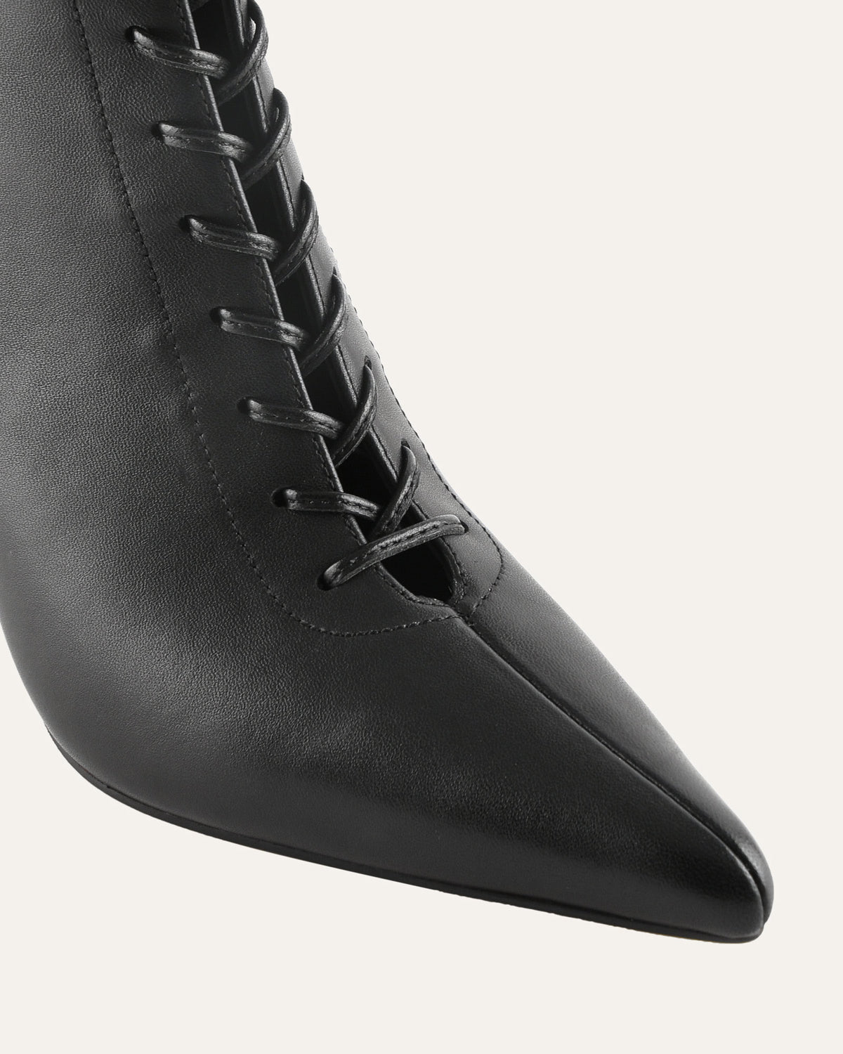 Black pointed-toe boot with laces on a white background