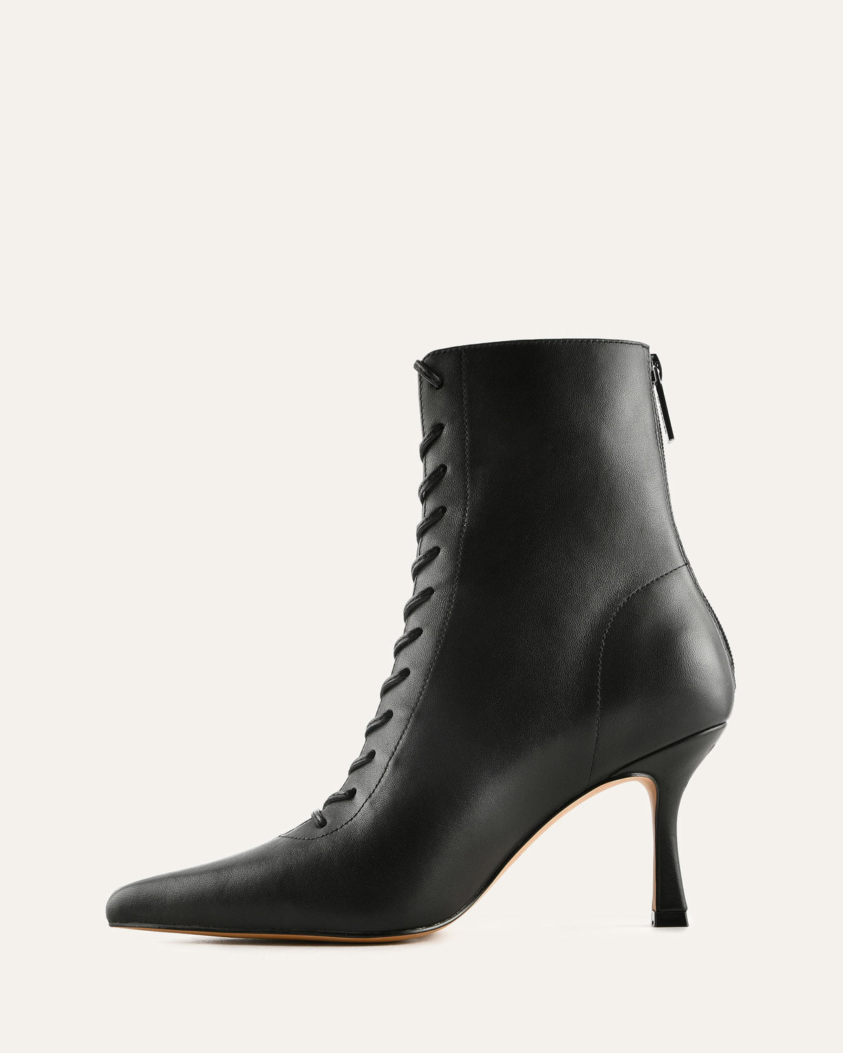 Black leather ankle boot with high heel on a light gray background