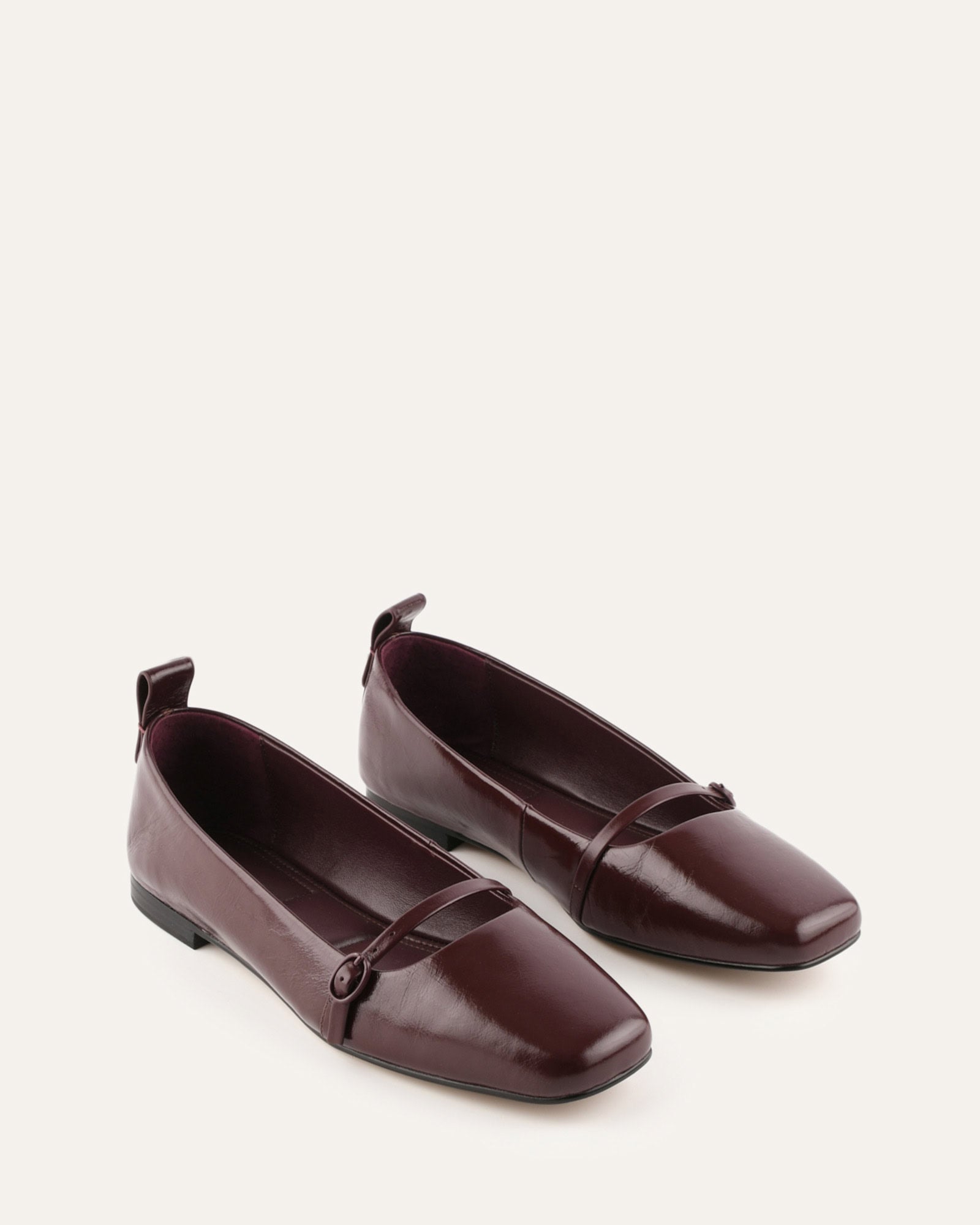 Brown flat shoe with a strap on a white background