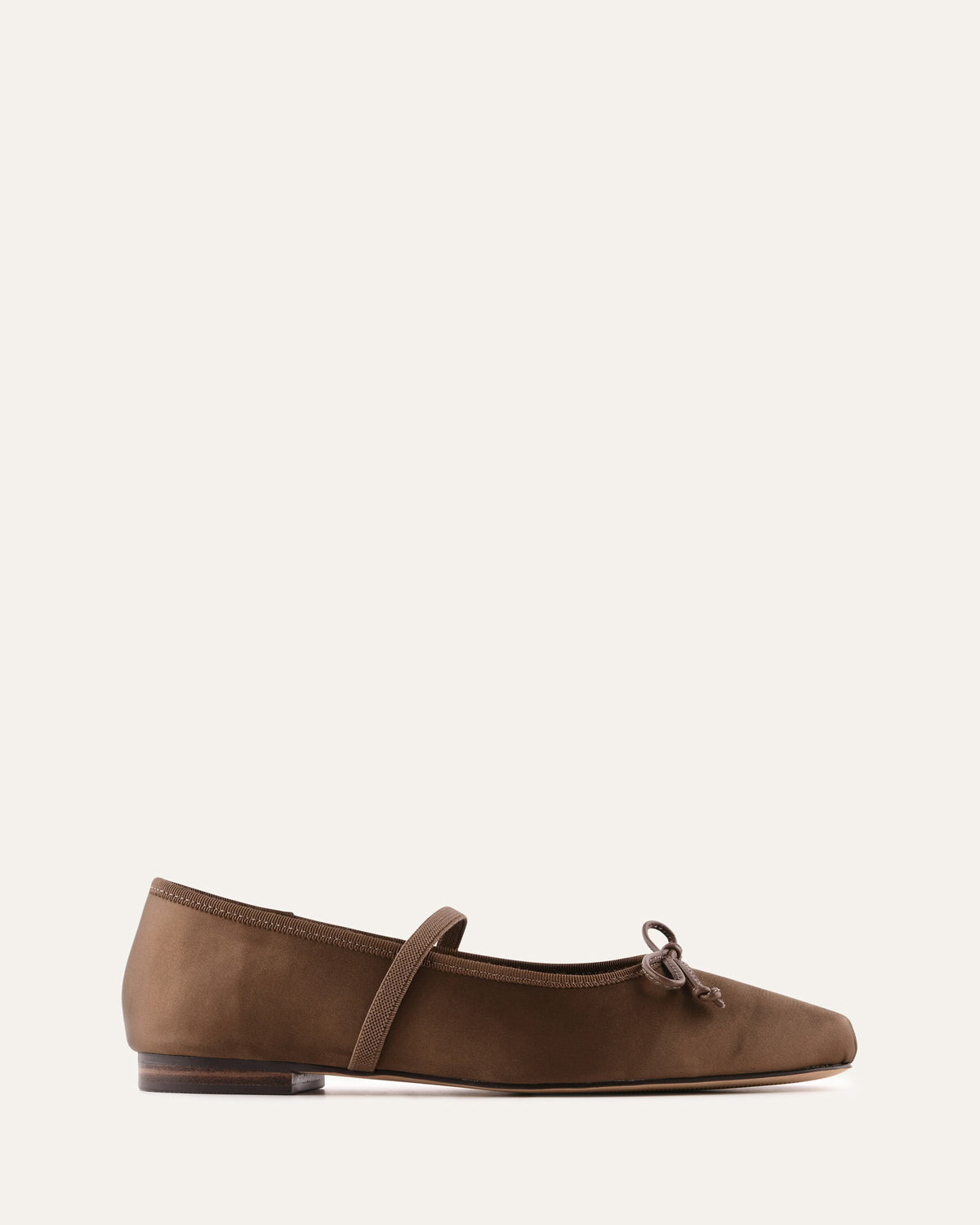 Brown flat shoe with a strap on a white background