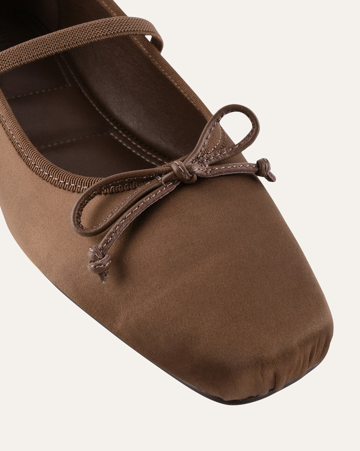 Brown ballet shoe with a bow on a white background