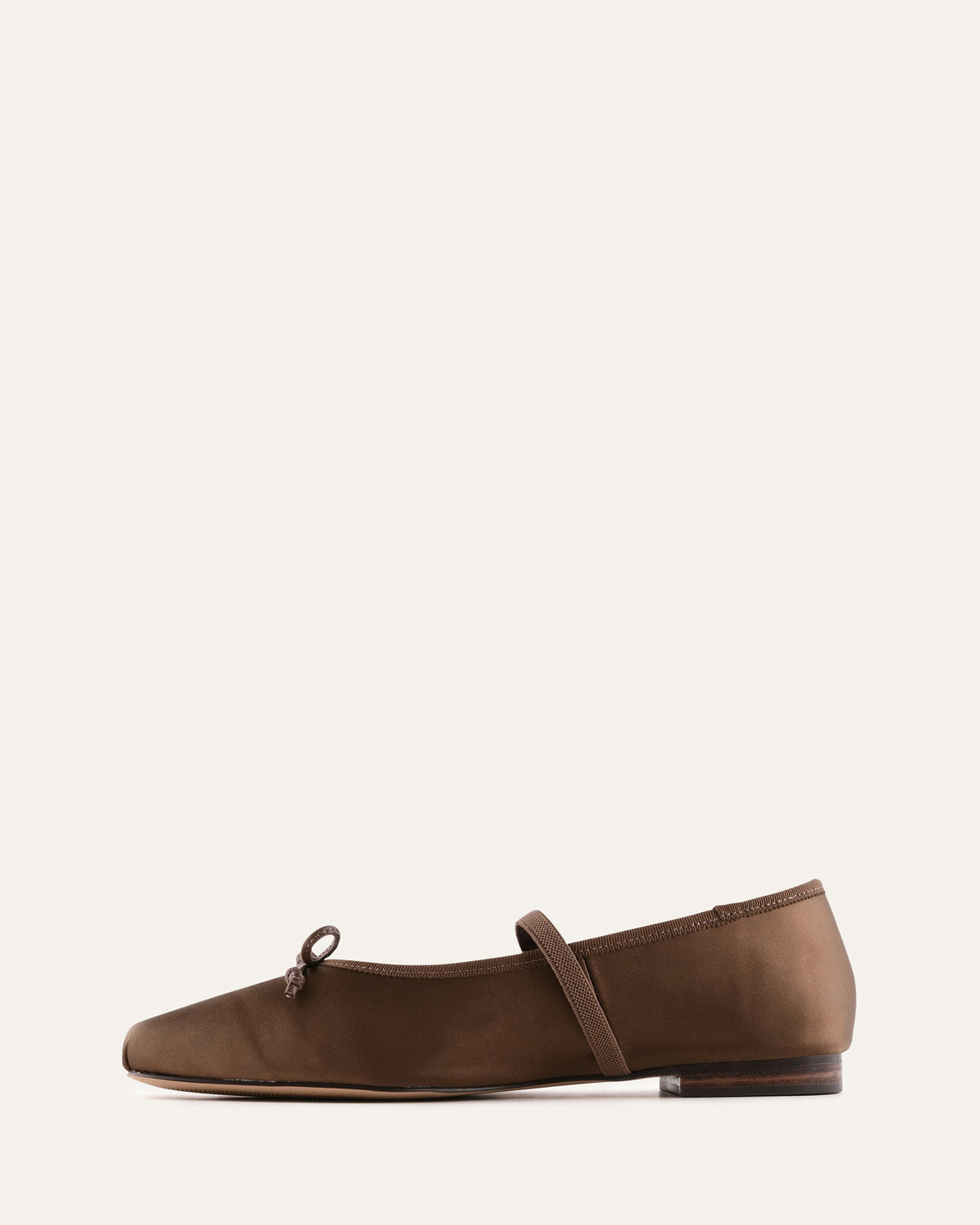 Brown flat shoe with a strap on a white background