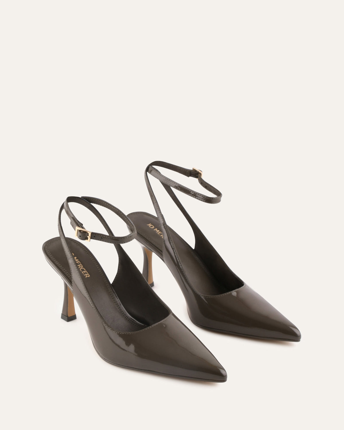 Pair of black high-heeled shoes with slingback design on a light gray background