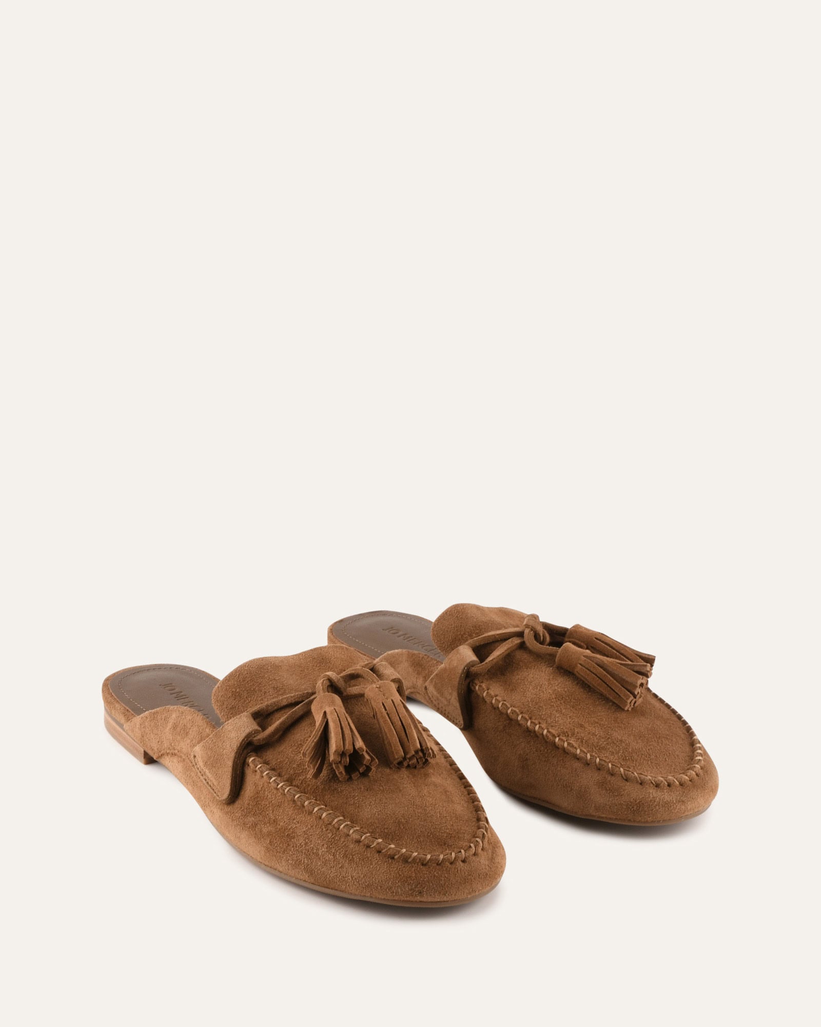 Brown suede loafer with bow detail on a white background