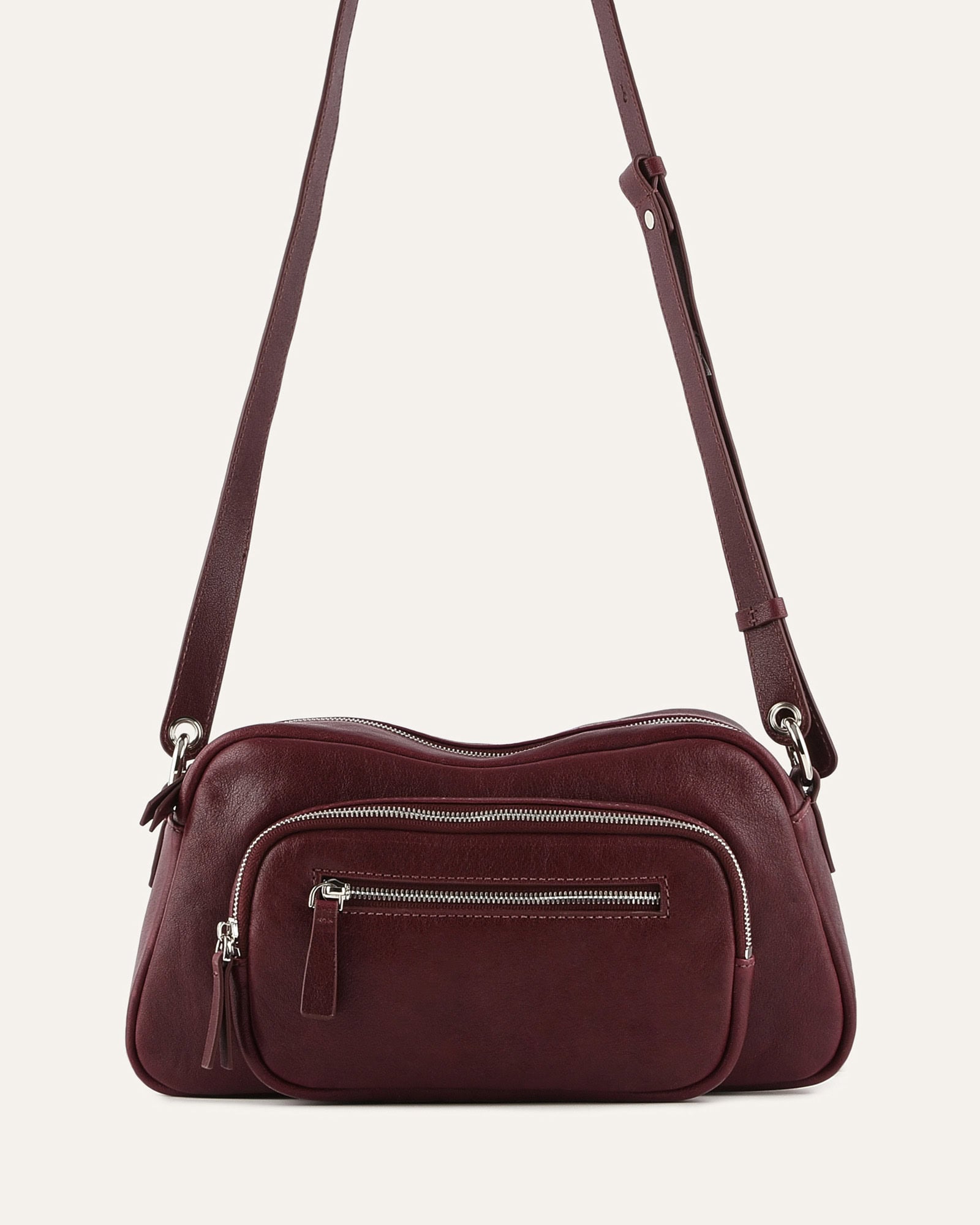 Burgundy leather crossbody bag on a light beige background