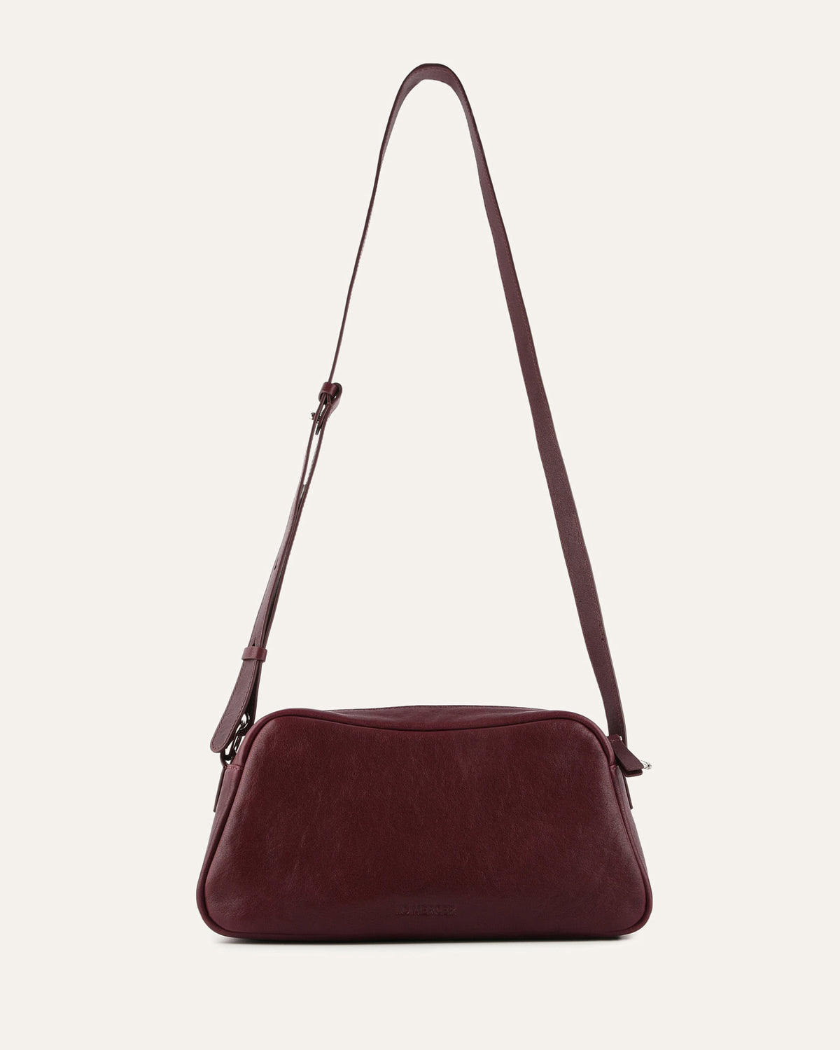 Burgundy handbag with a strap on a light beige background