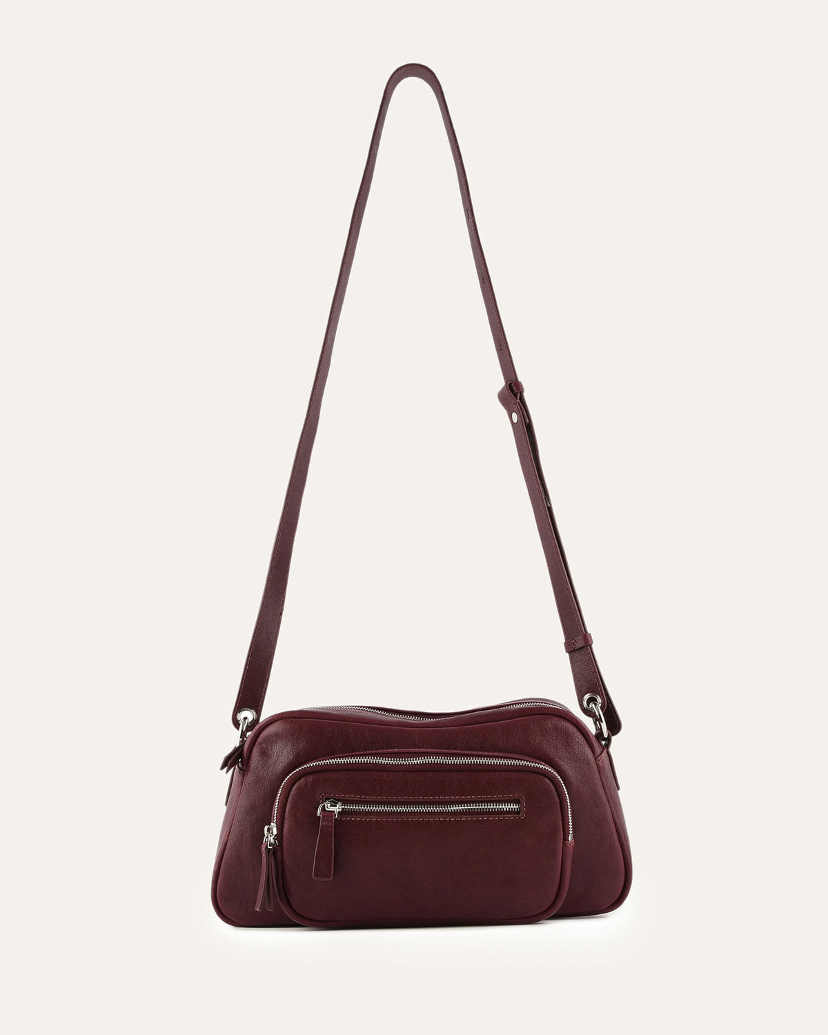 Burgundy handbag with a strap on a light beige background