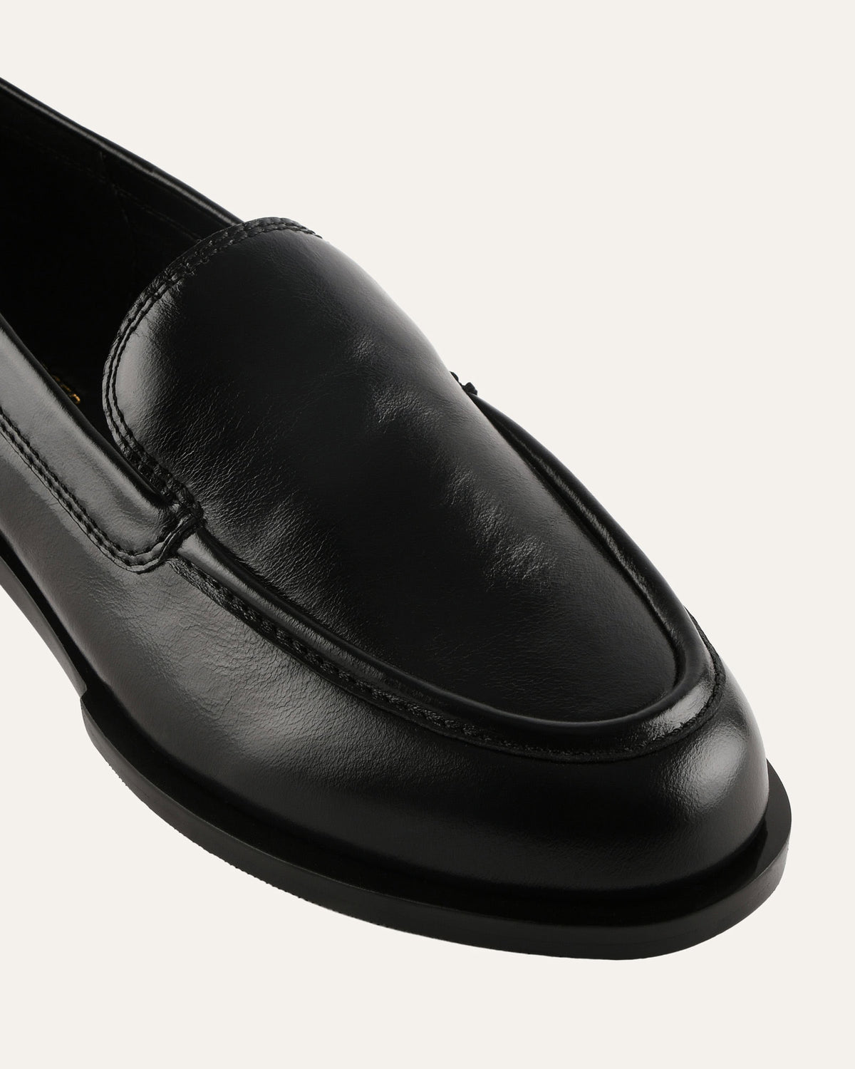 Black loafer shoe on a light gray background