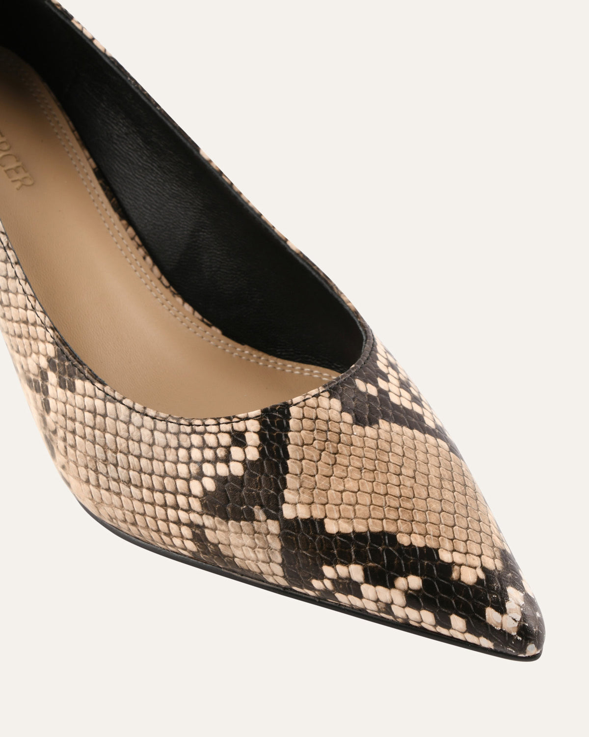 Pointed-toe shoe with snake print pattern on a white background