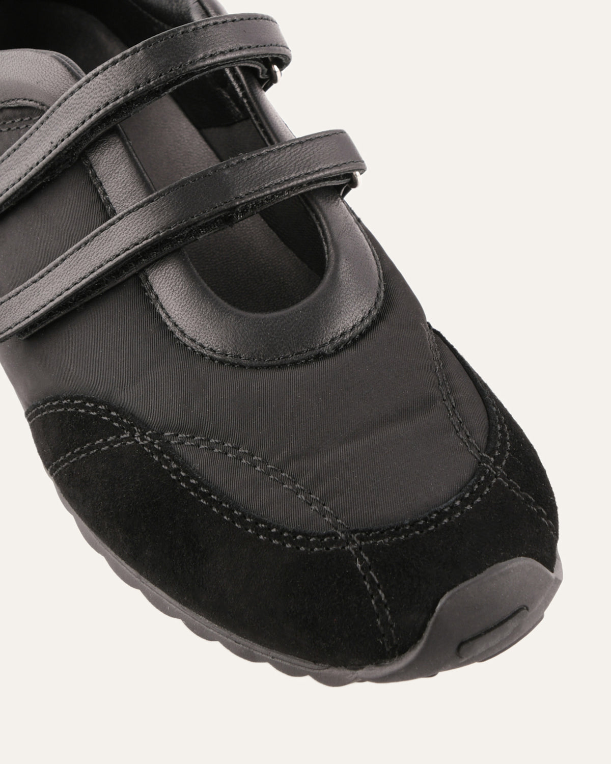 Black shoe with a velcro strap on a white background