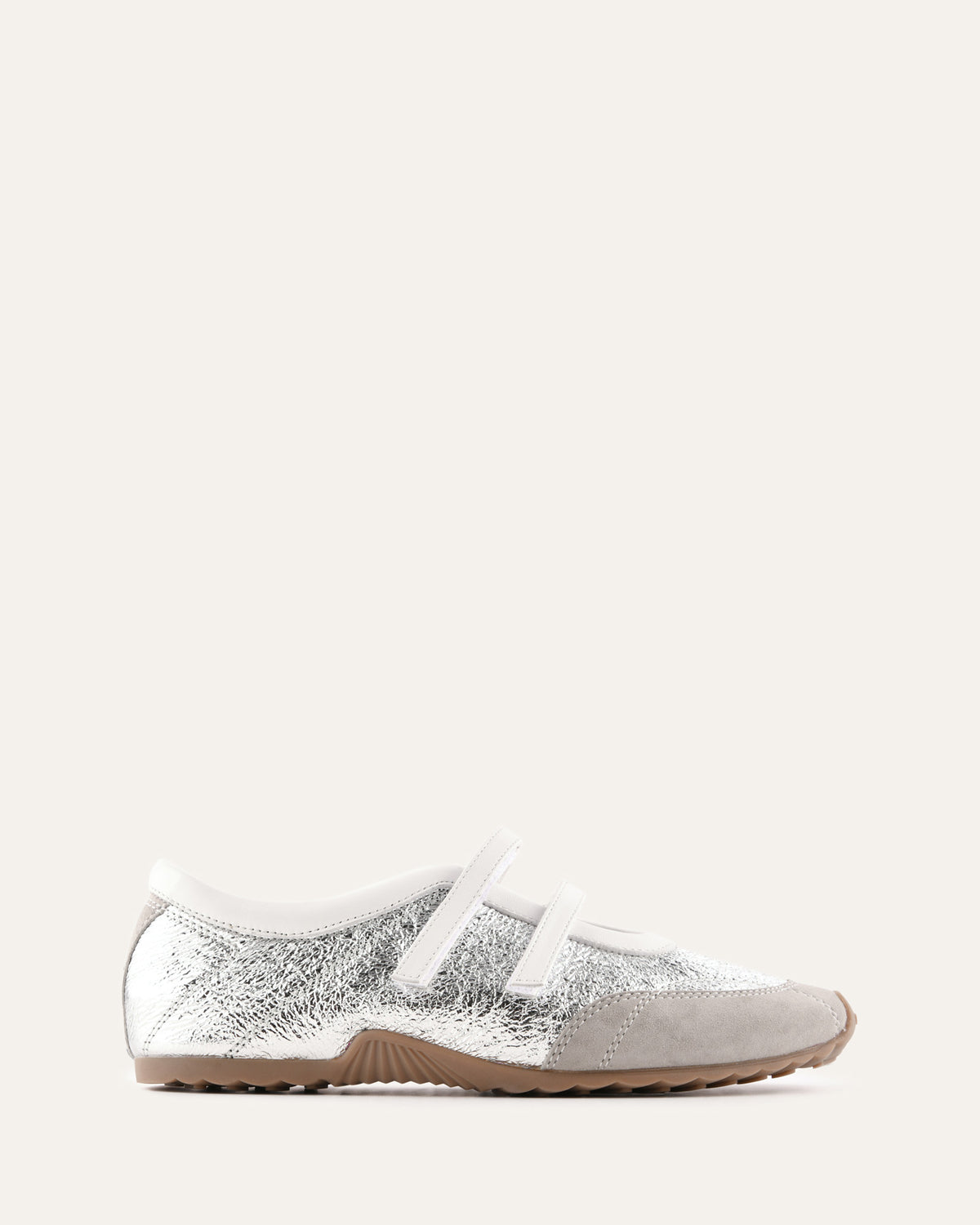 Silver glitter sneaker with white sole on a light beige background