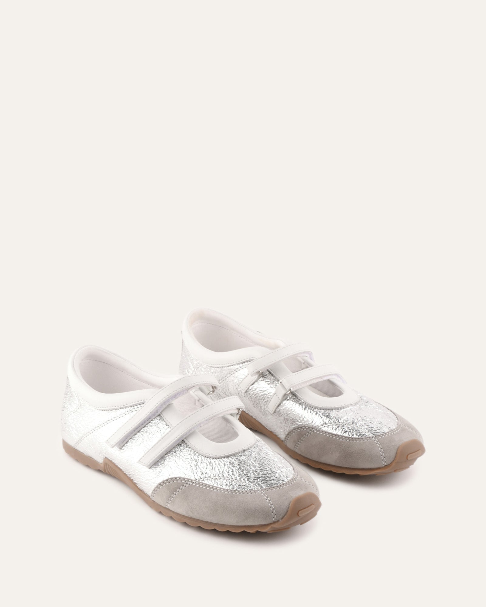 Silver glitter sneaker with white sole on a light beige background