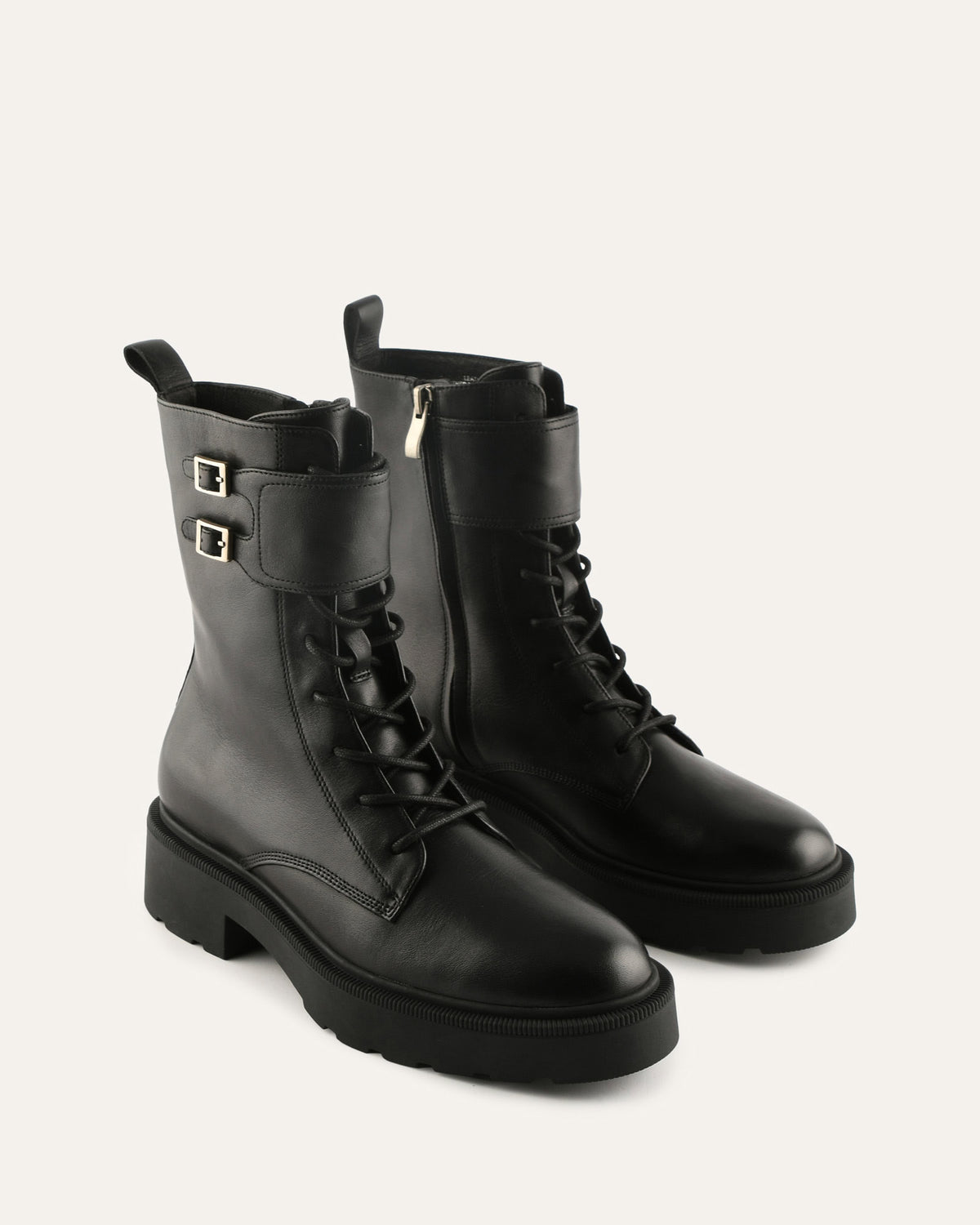 Pair of black leather boots with lace-up design on a light gray background