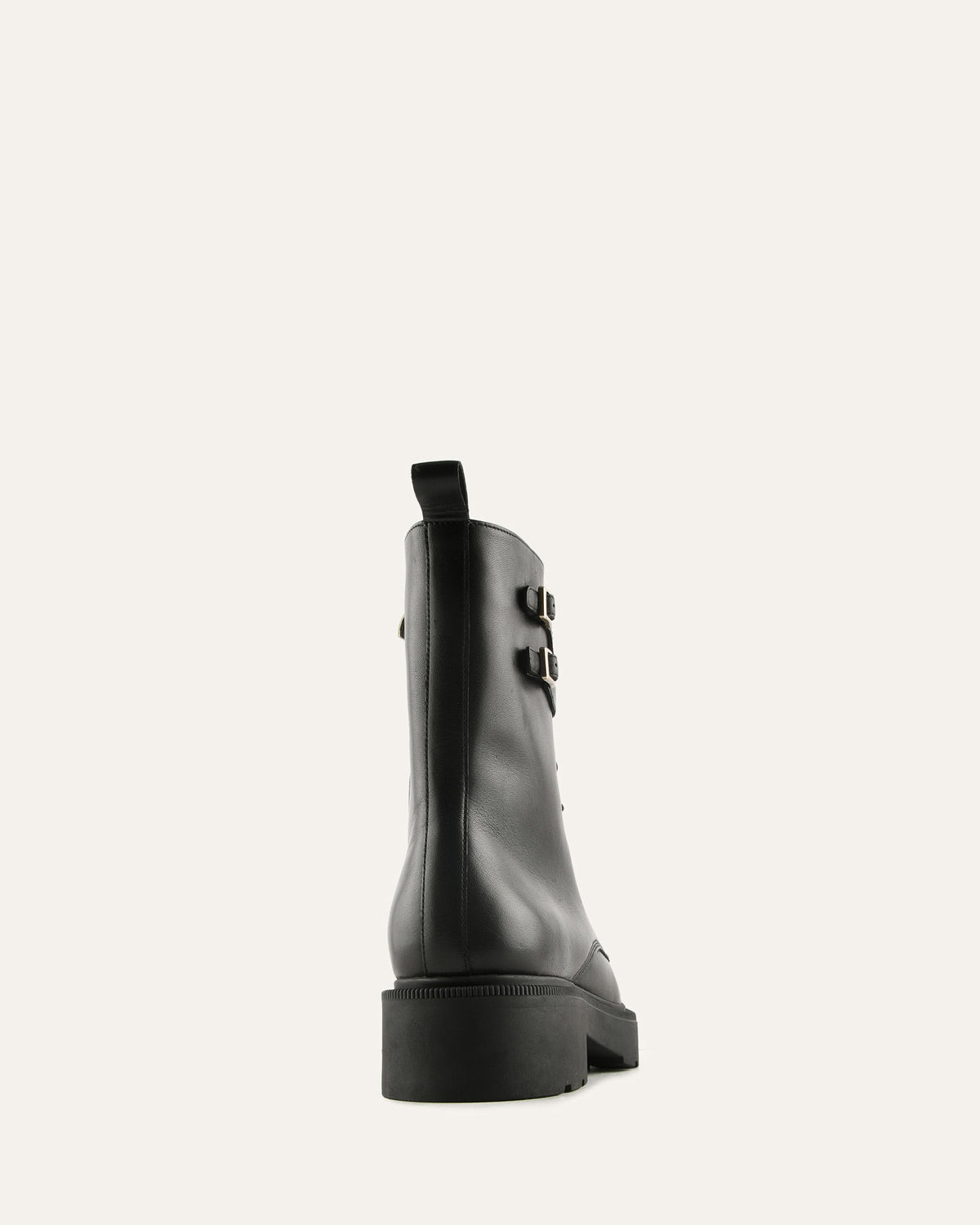 Black leather boot with buckle detail on a white background