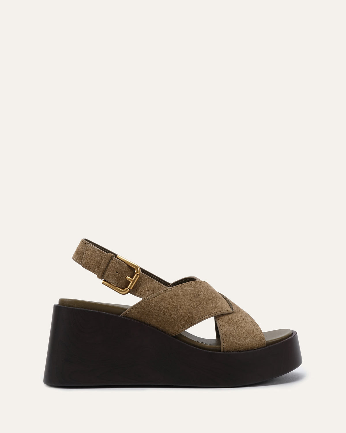A single platform wedge sandal in taupe suede with a black sole and a gold buckle, shown from a side profile on a light off-white background.