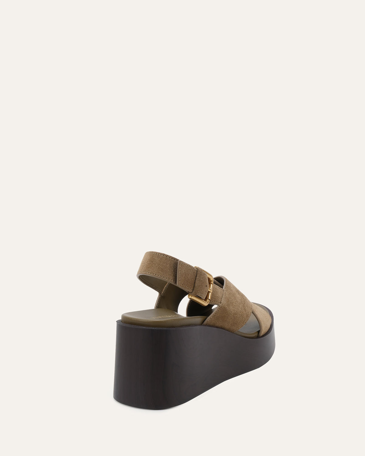 A single platform sandal shown from a rear three-quarter angle against a solid off-white background. The sandal features wide taupe-brown straps with a small gold-tone buckle and a thick, dark brown platform heel.