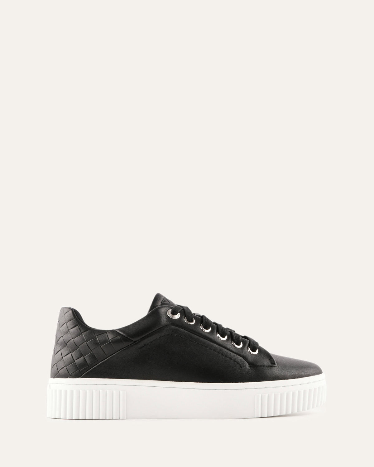 Black sneaker with white sole on a light gray background