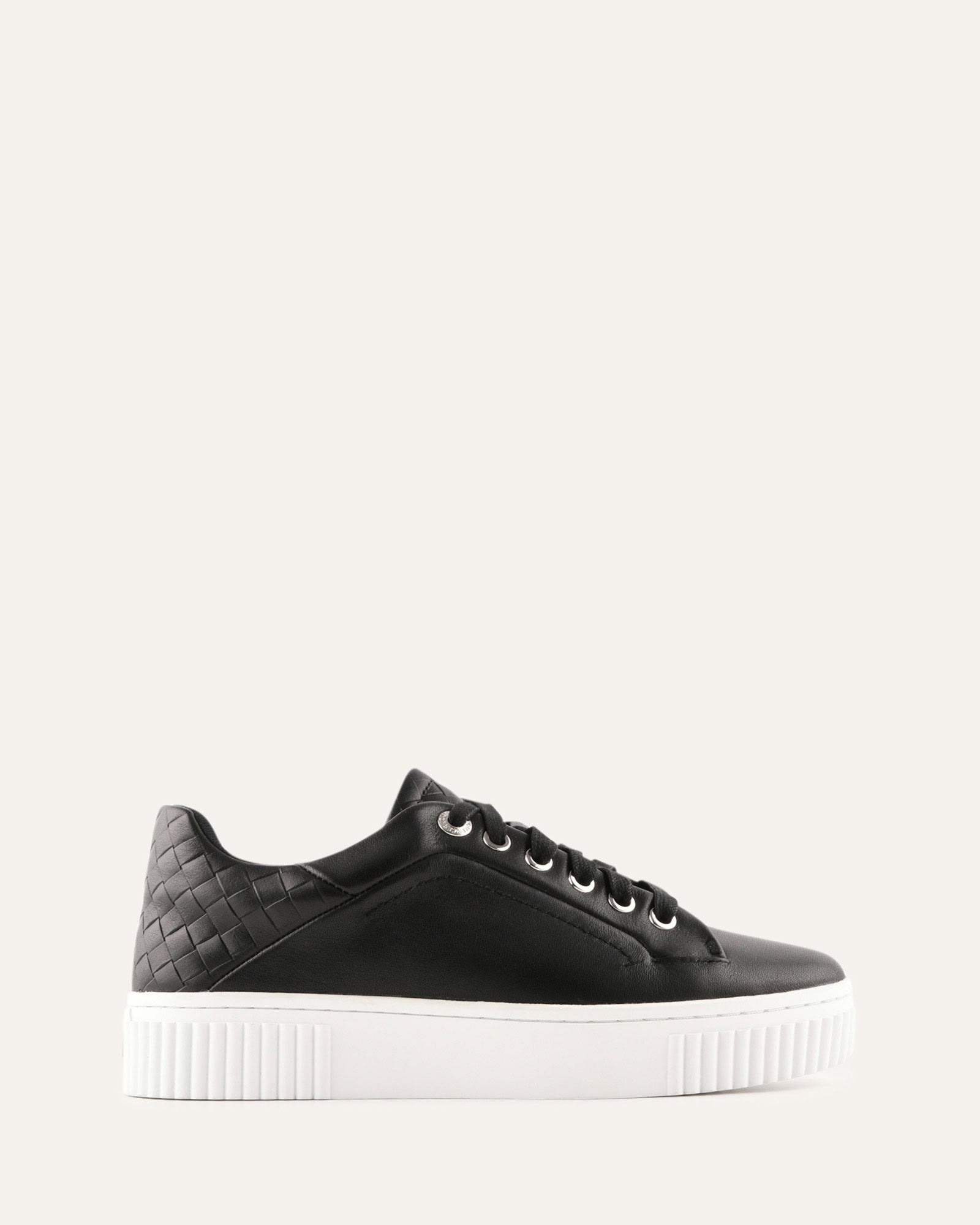 Black sneaker with white sole on a light gray background
