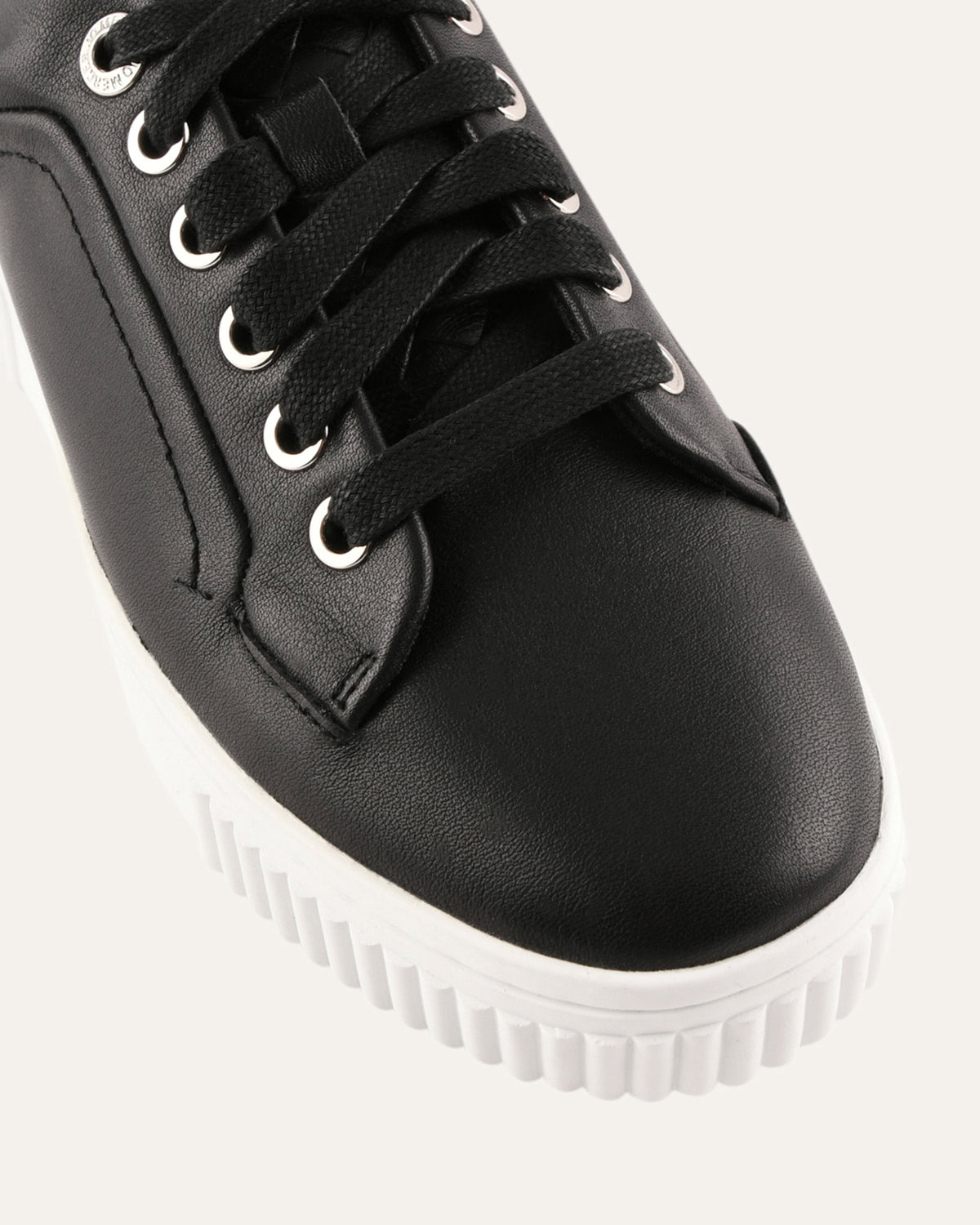 Black sneaker with white sole on a light gray background