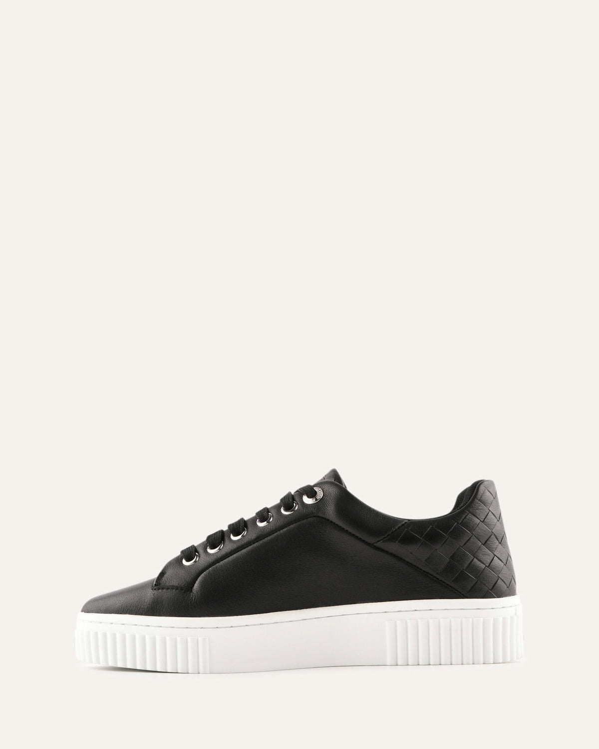 Black sneaker with white sole on a light gray background