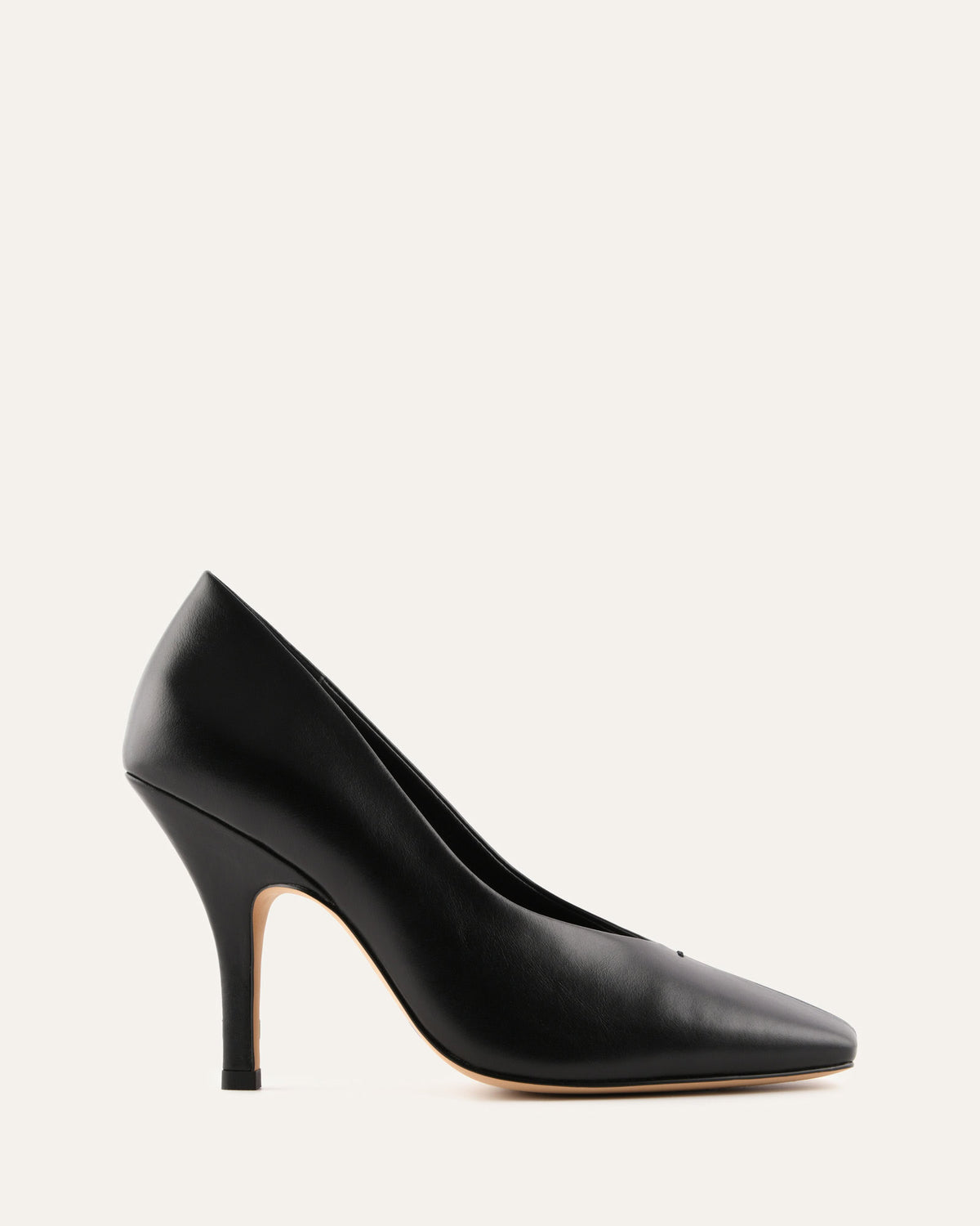 Black high-heeled shoe on a light beige background