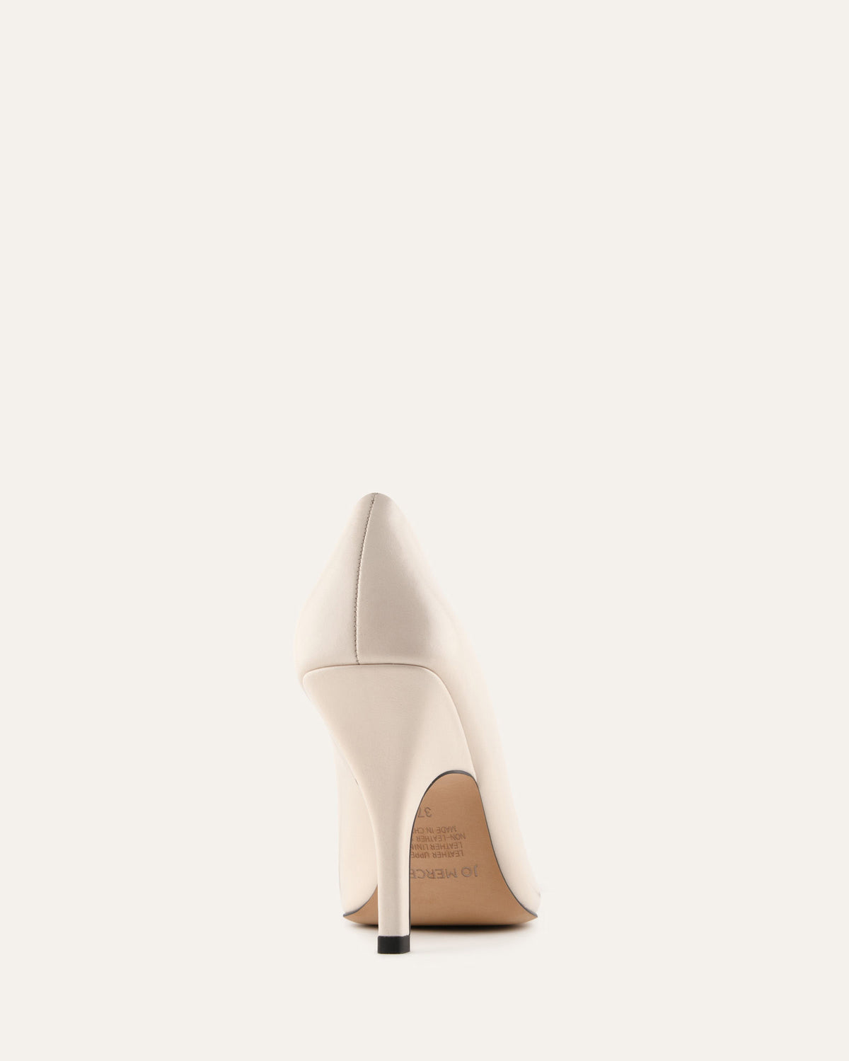 White high-heeled shoe on a light beige background