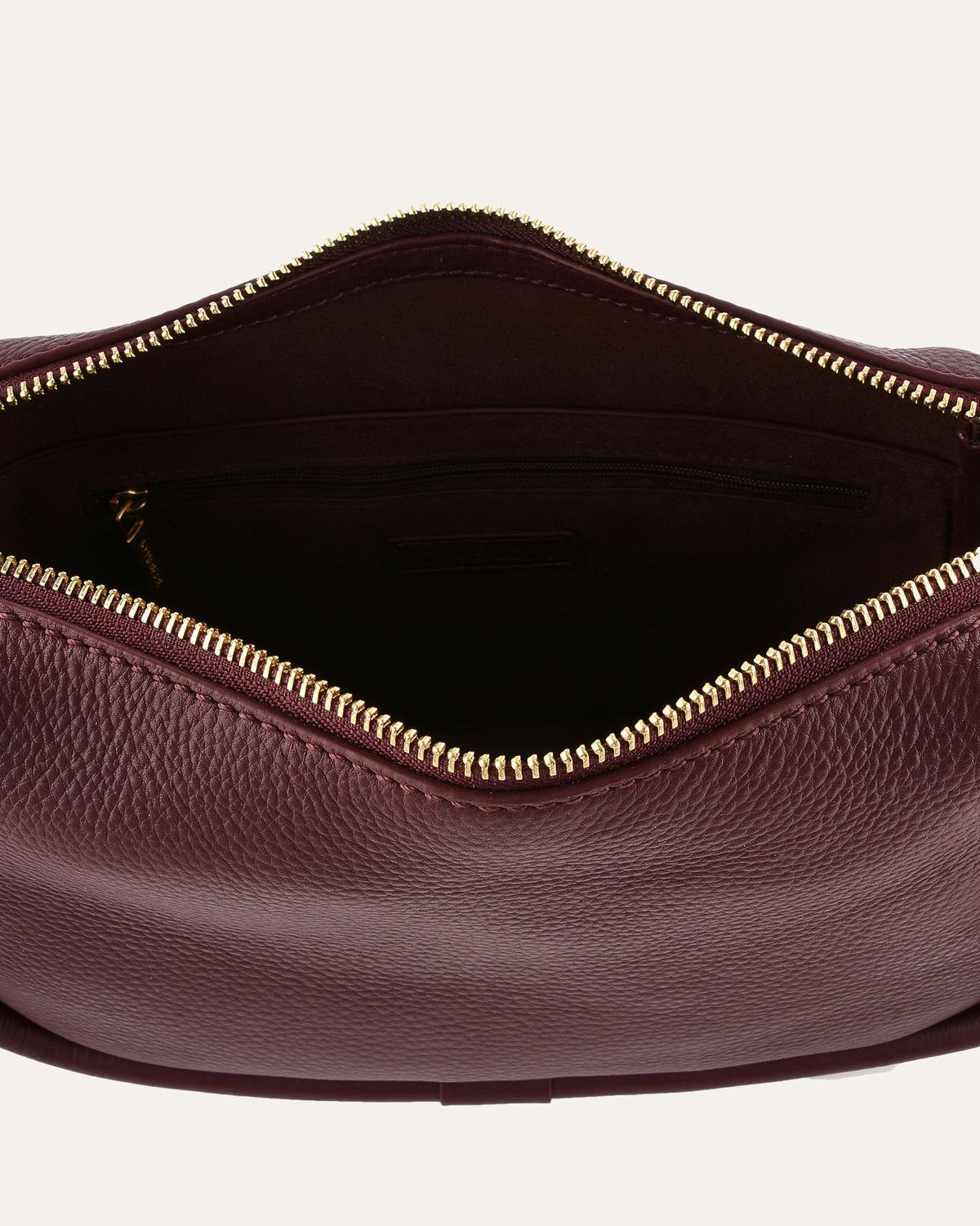Close-up of a maroon leather bag with a gold zipper on a white background