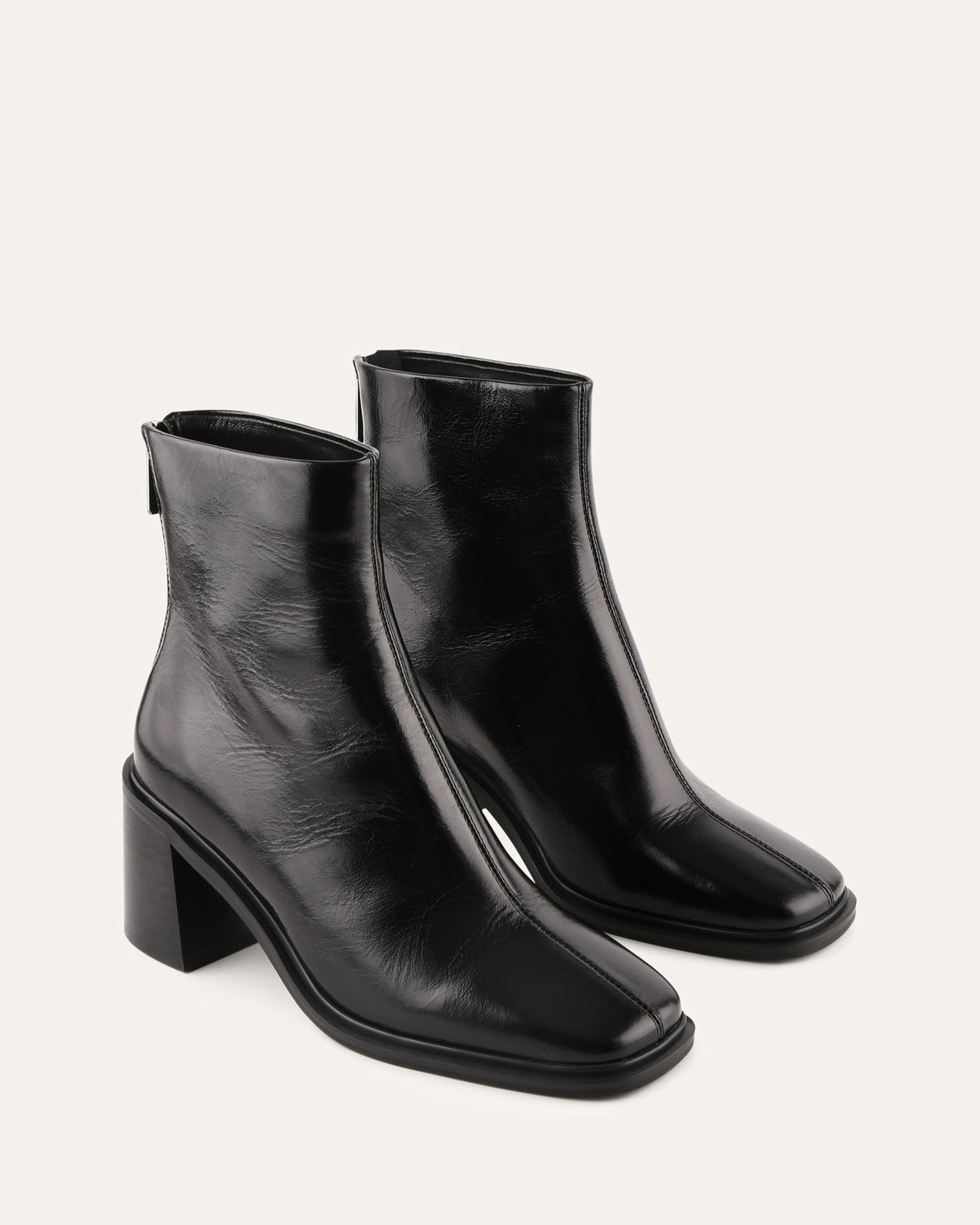 Pair of black leather ankle boots on a light gray background