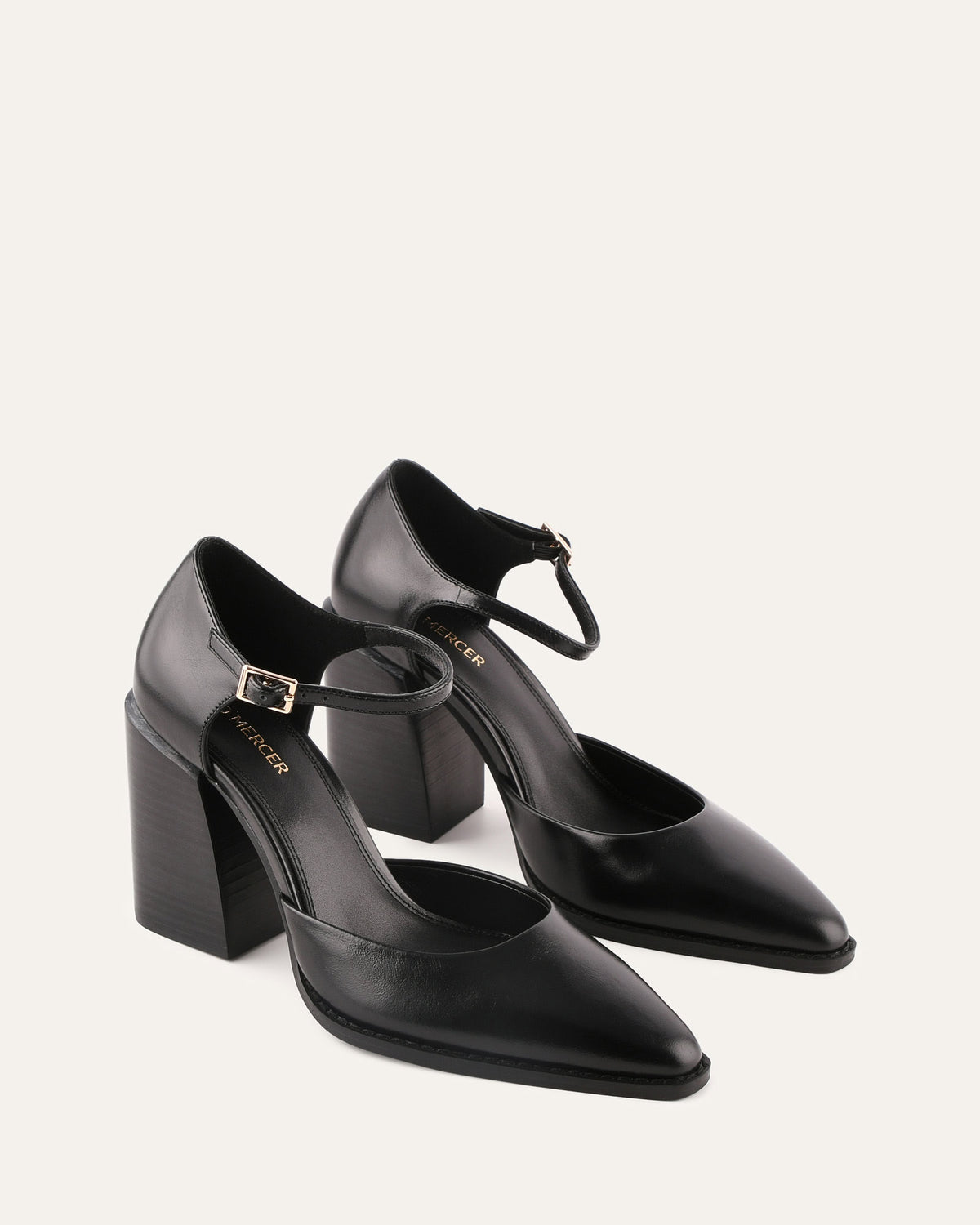 Black high-heeled shoes with ankle straps on a white background