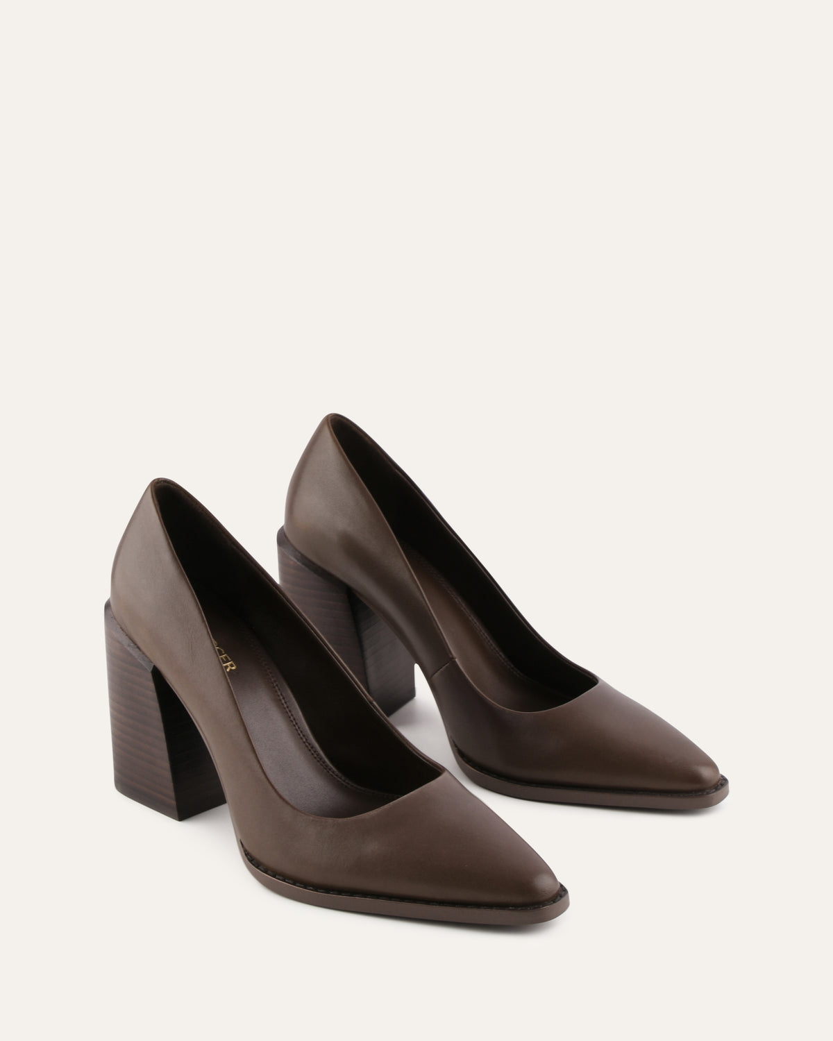 Pair of brown high-heeled shoes on a light beige background