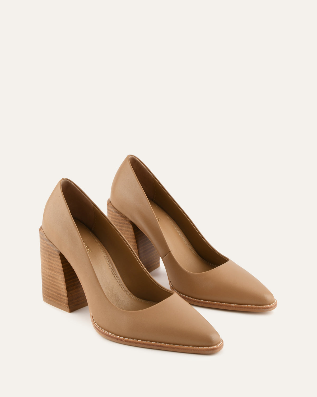 Pair of tan high-heeled shoes on a light beige background