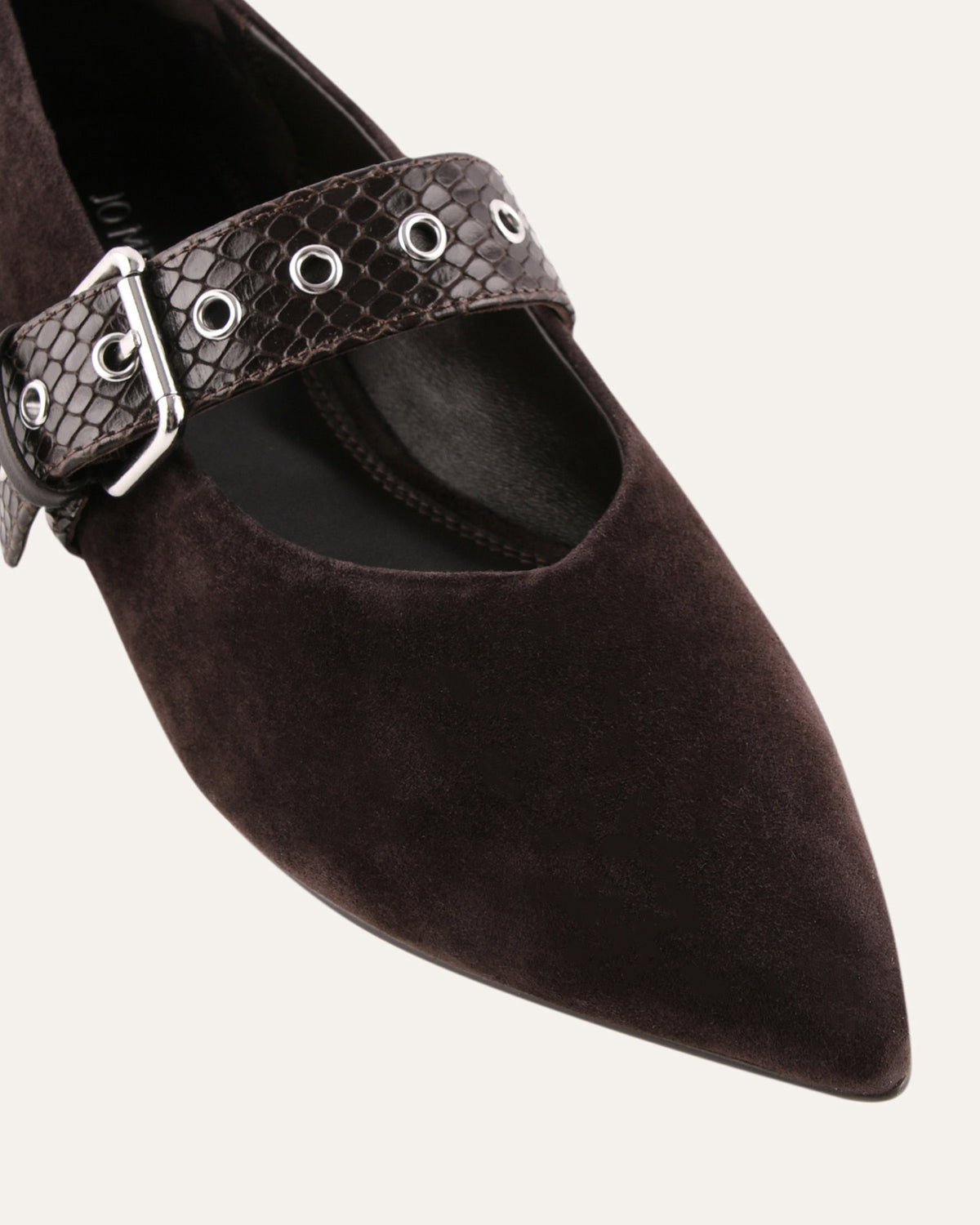 Brown pointed-toe shoe with a studded strap on a white background