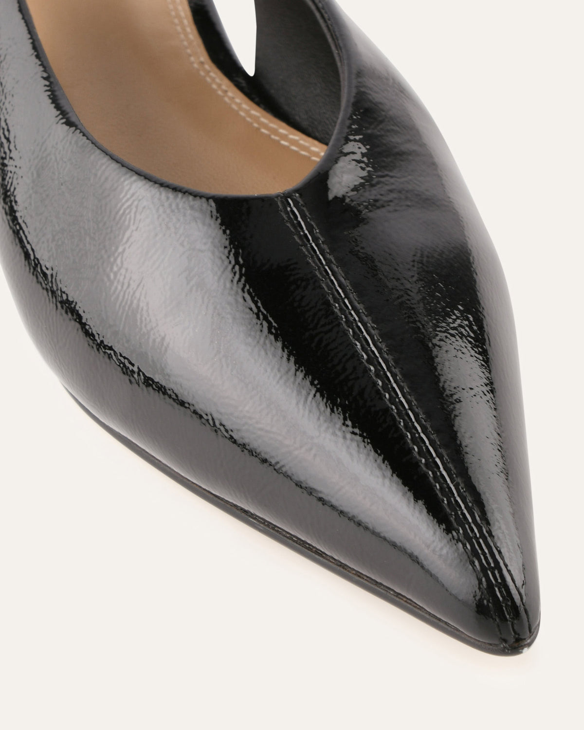 Black patent leather pointed-toe shoe on a white background