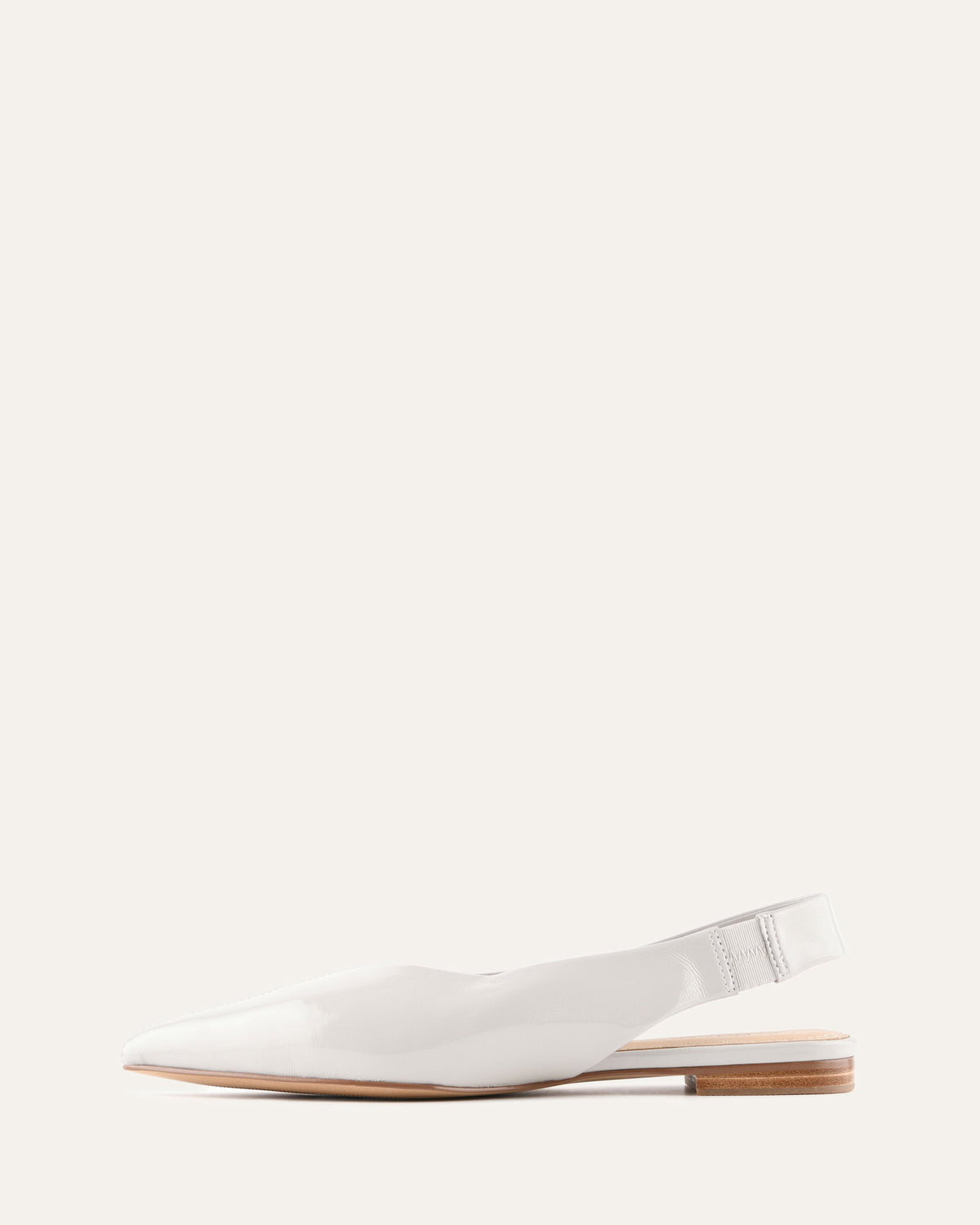 White flat shoe with a slingback design on a white background