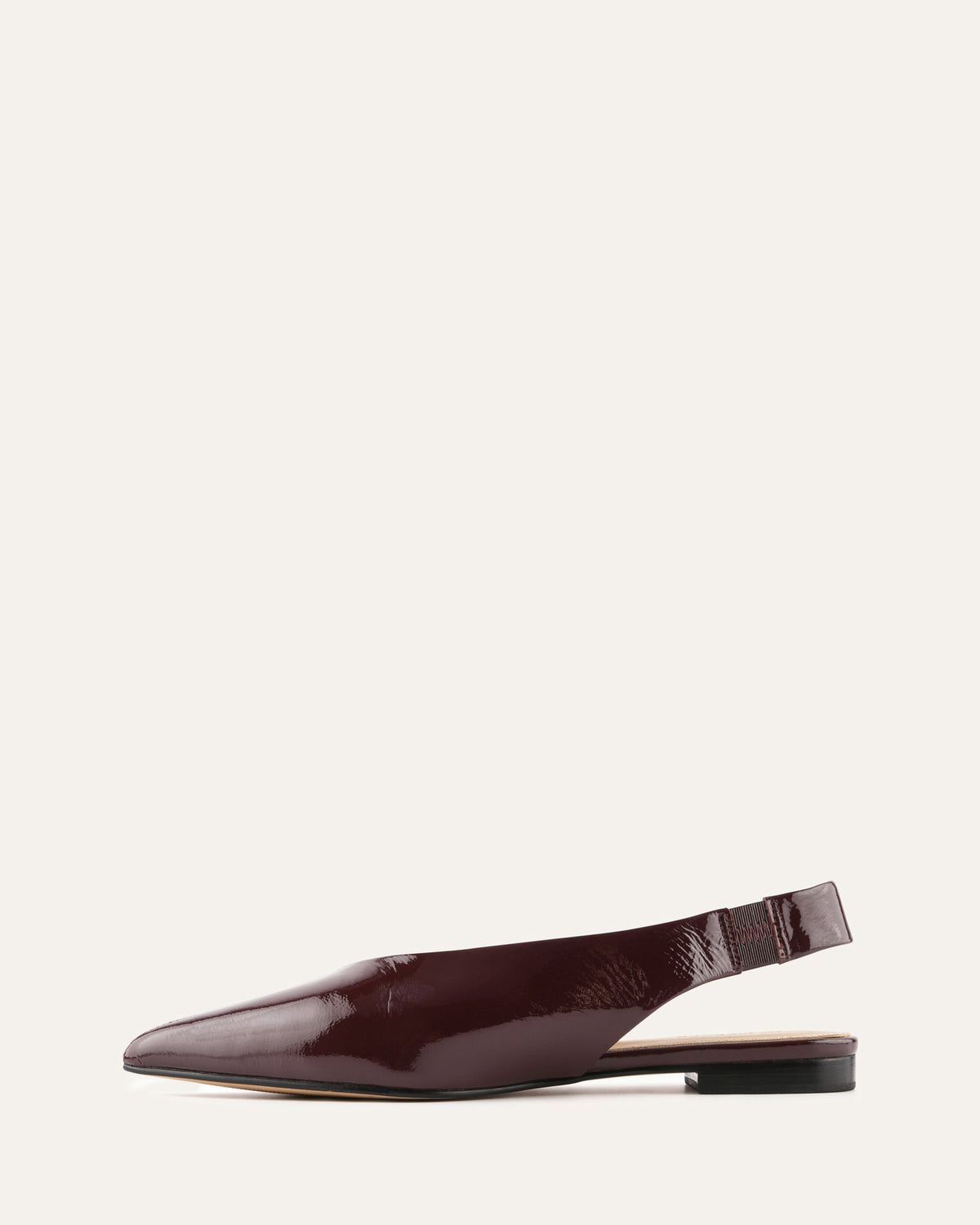 Burgundy slingback flat shoe on a light beige background