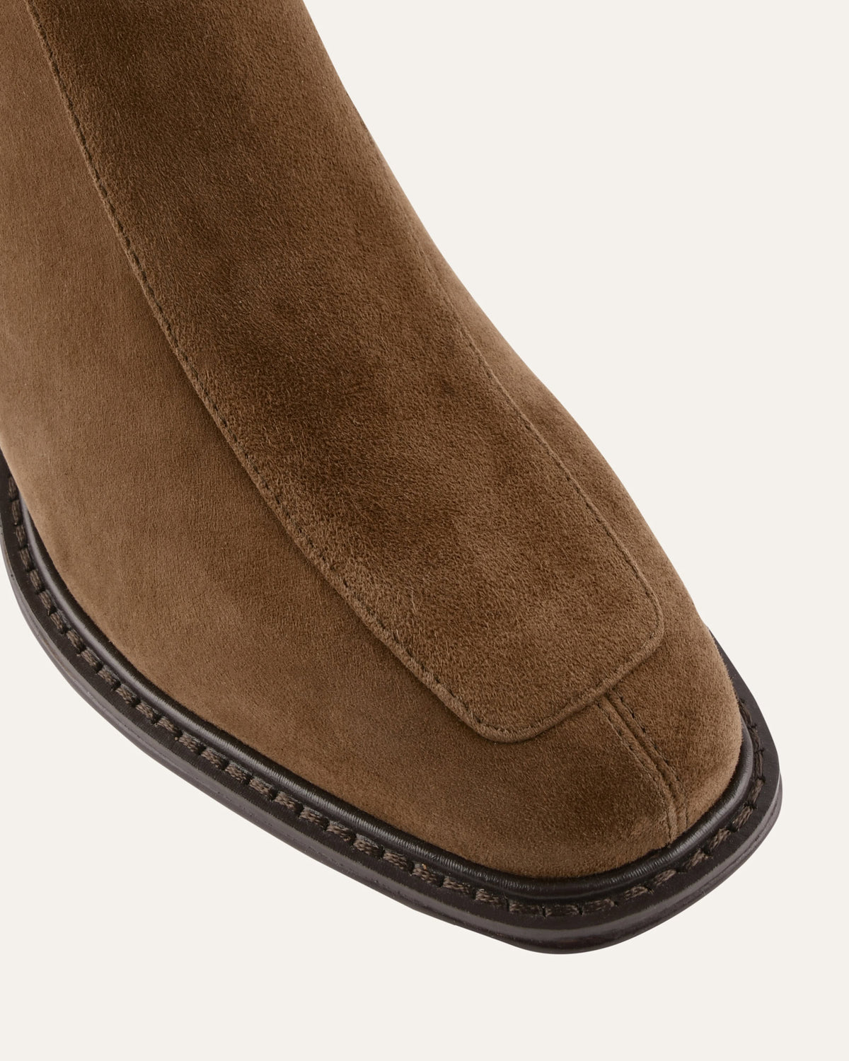 Brown suede shoe with a black sole on a white background