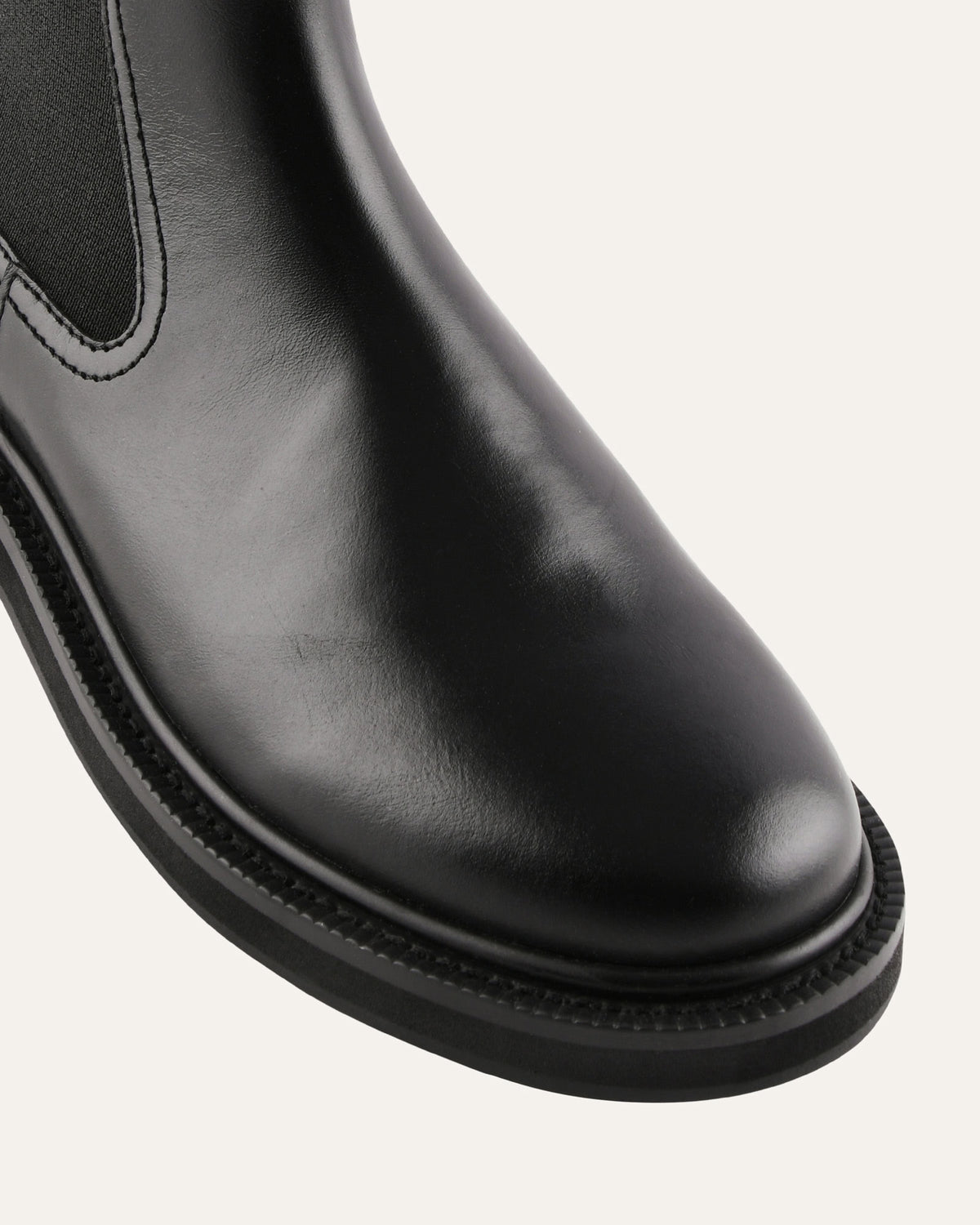 Close-up of a black leather boot on a white background
