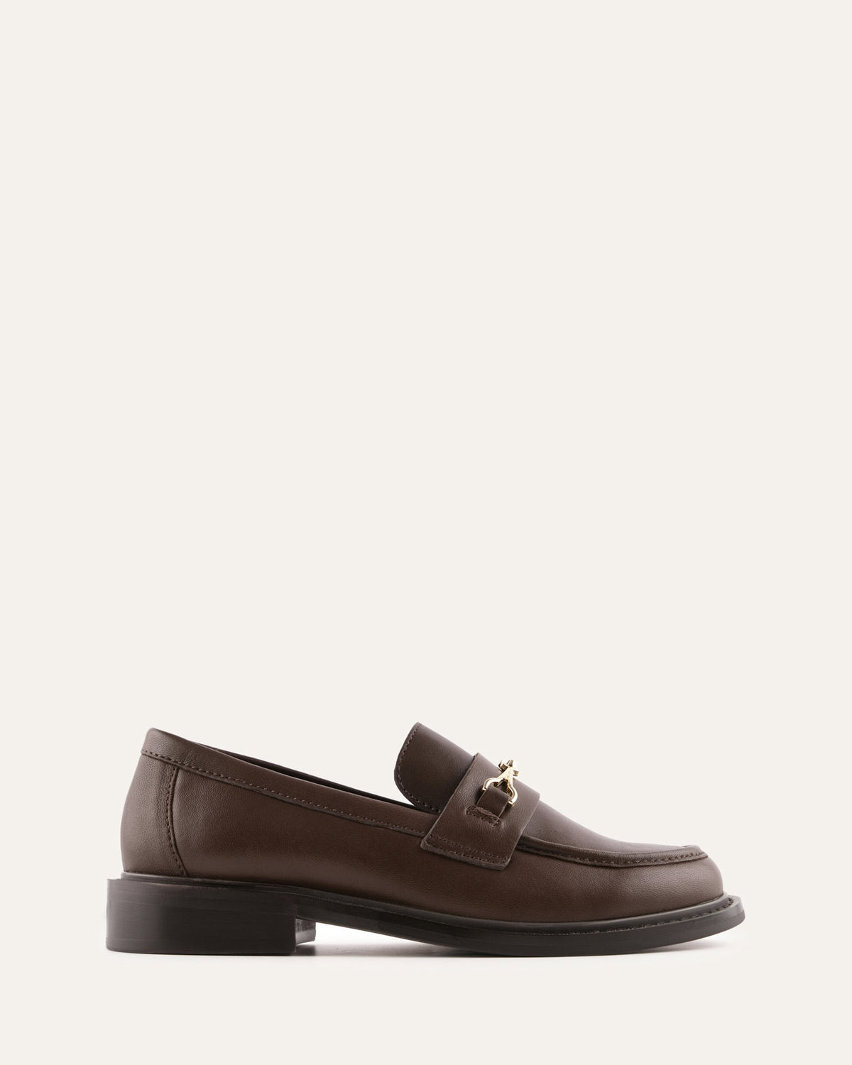 Brown leather loafer with a gold buckle on a white background