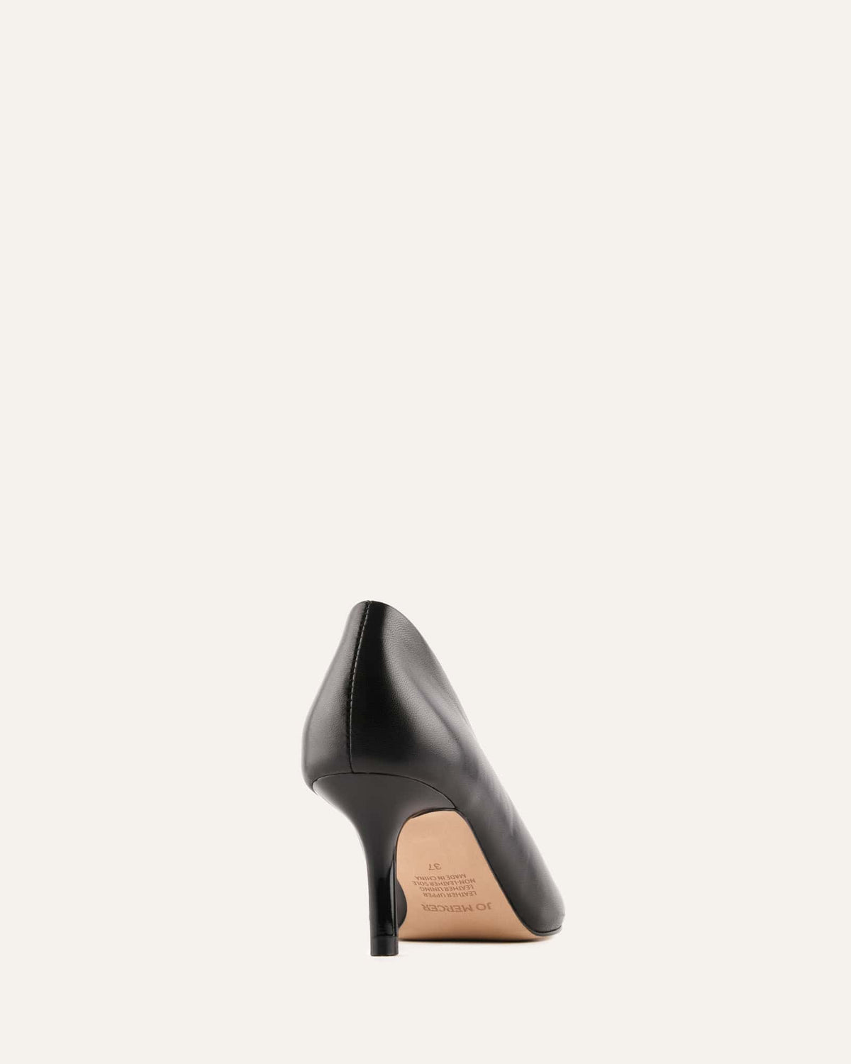 Black high-heeled shoe on a light beige background