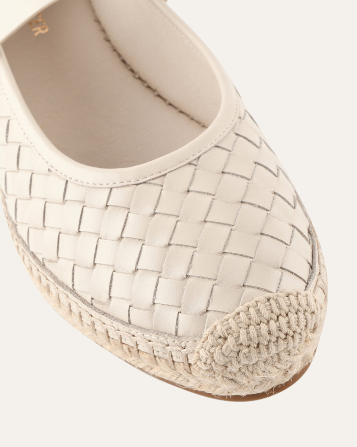 Beige woven espadrille shoe on a white background