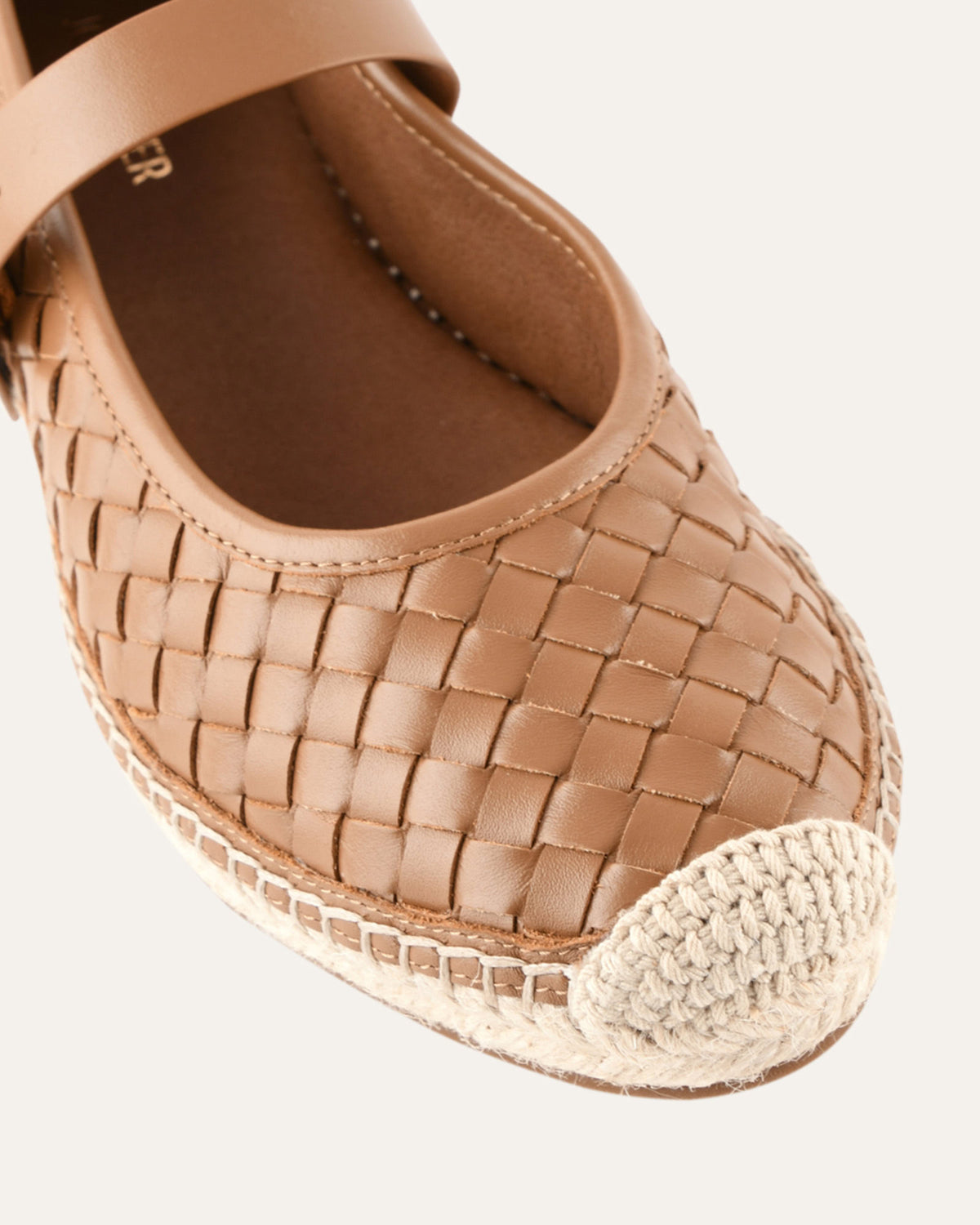 Brown woven espadrille shoe on a white background