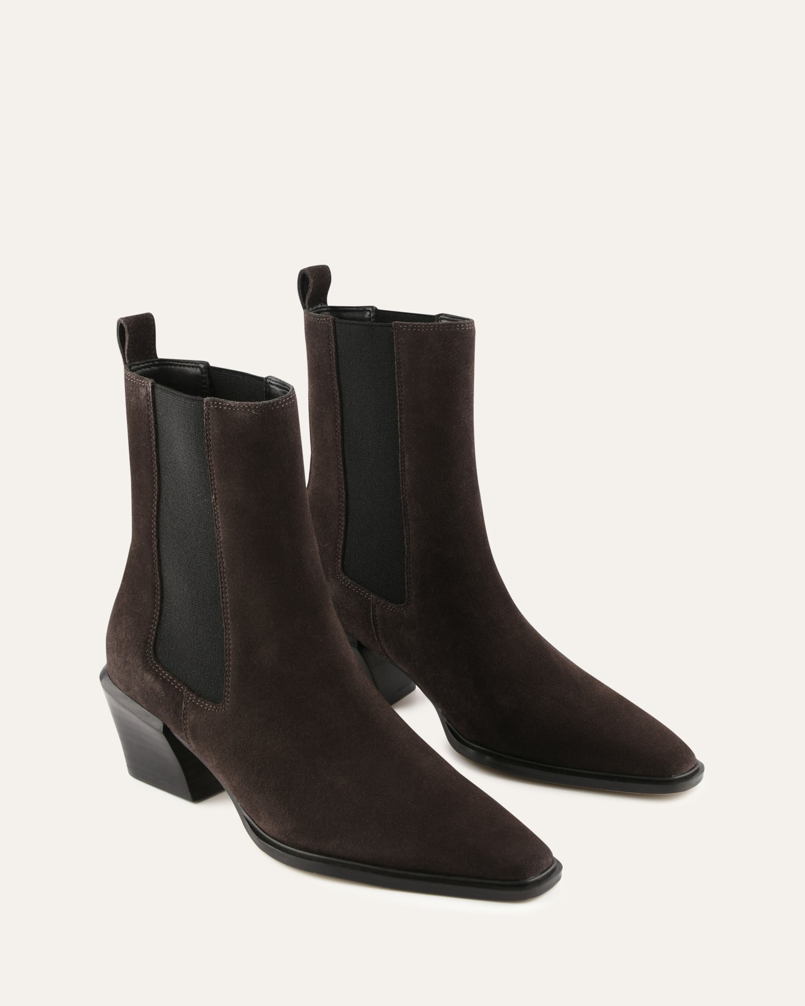 Brown suede ankle boots with a black block heel on a light gray background