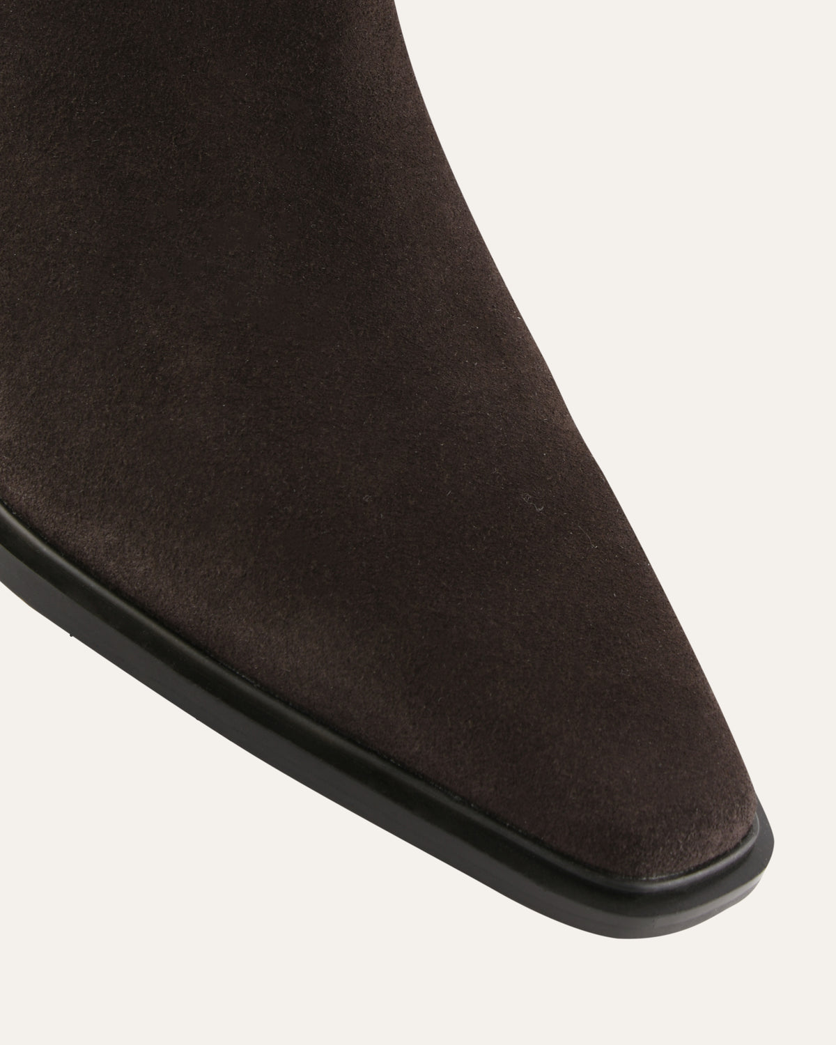 Close-up of a brown suede ankle boot on a white background