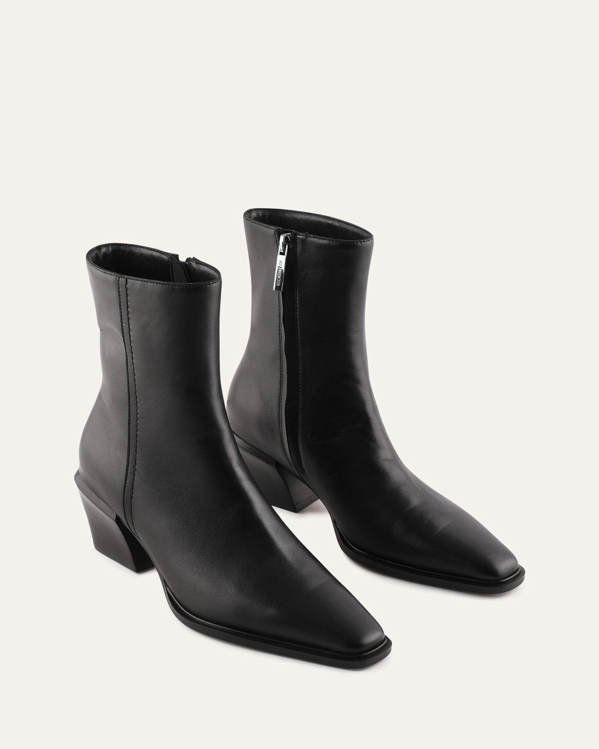 Pair of black leather ankle boots on a light gray background