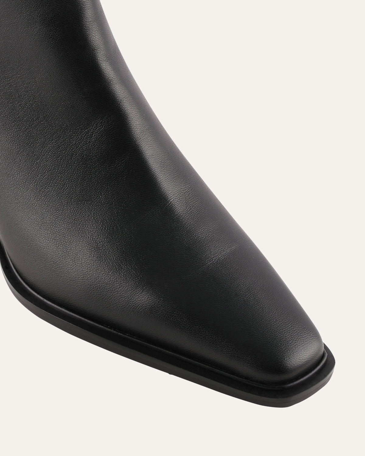 Close-up of a black leather boot on a white background