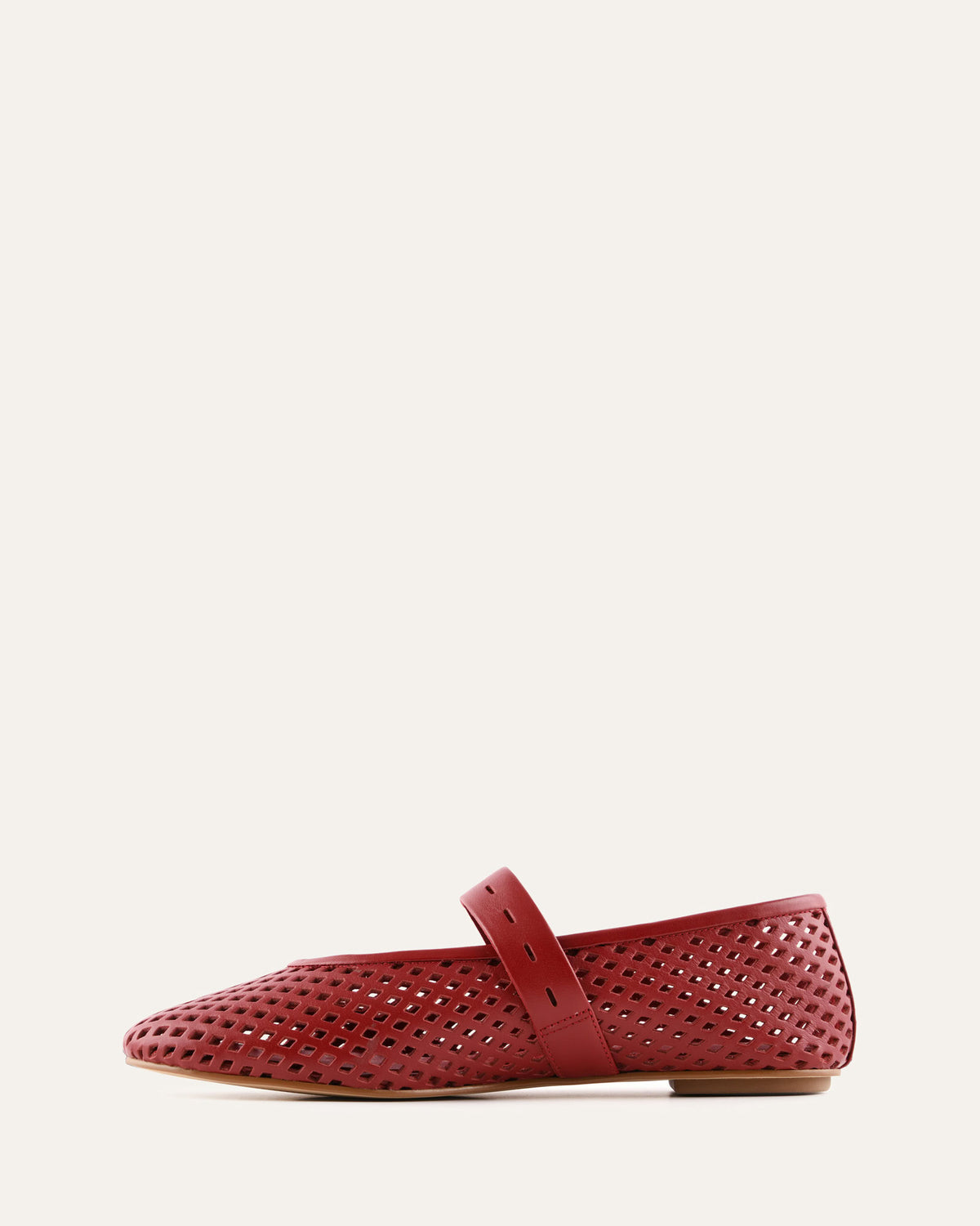 Red perforated flat shoe on a white background