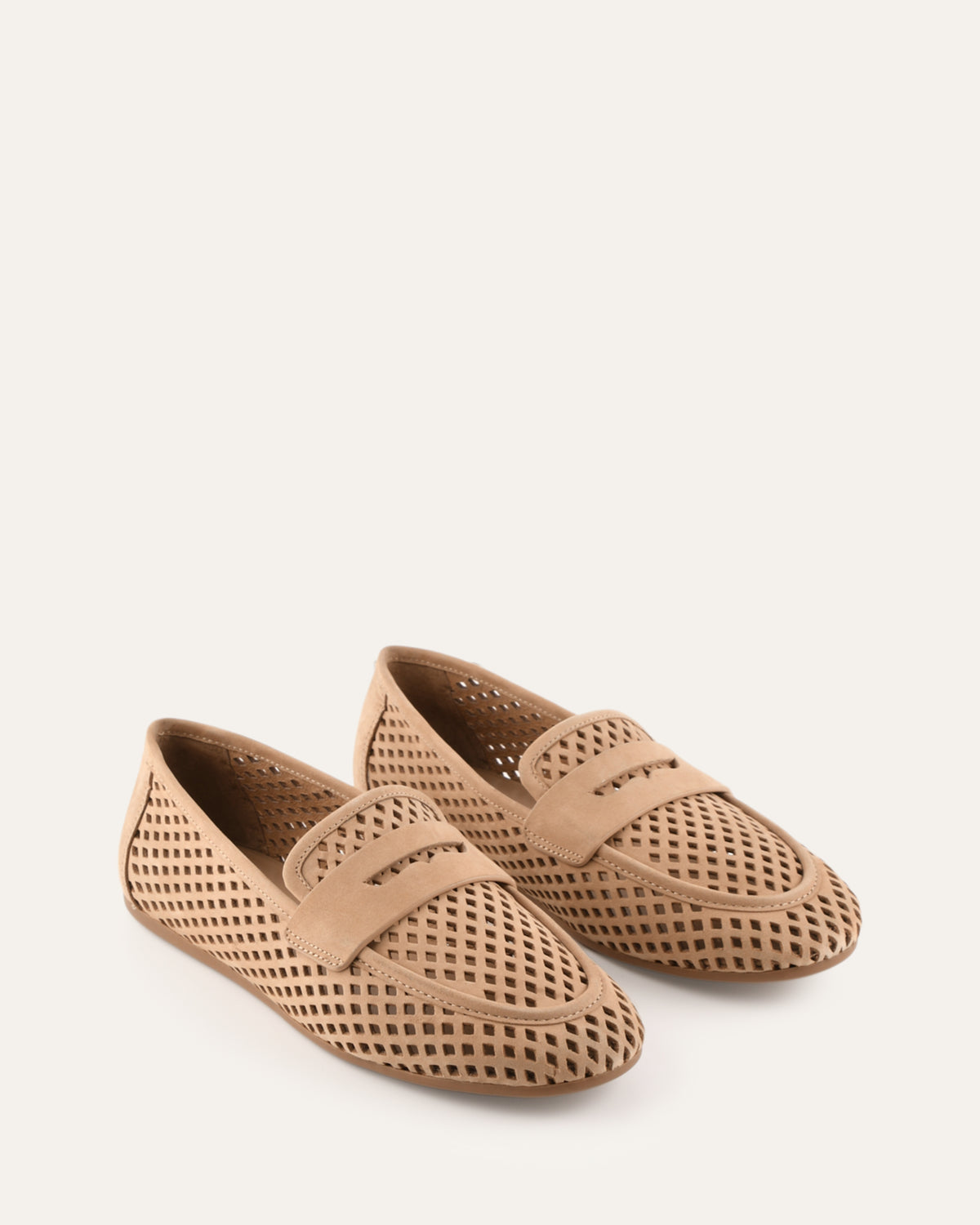 Pair of beige perforated loafers on a white background