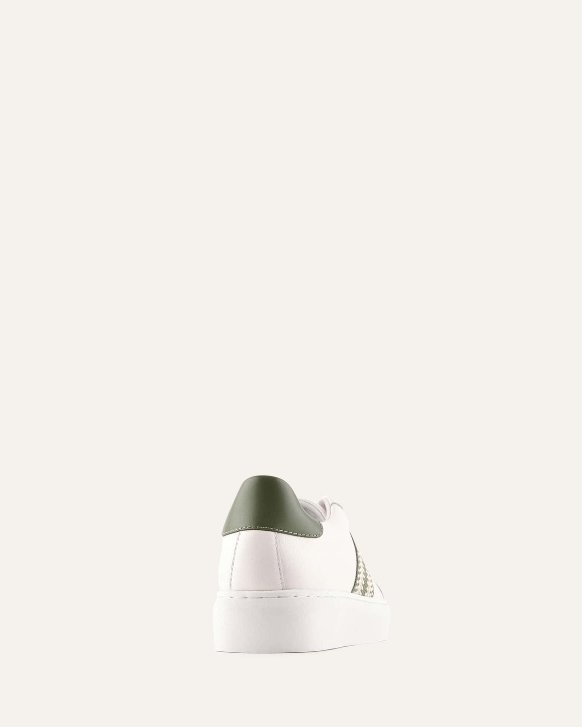 White sneaker with a green heel tab on a white background