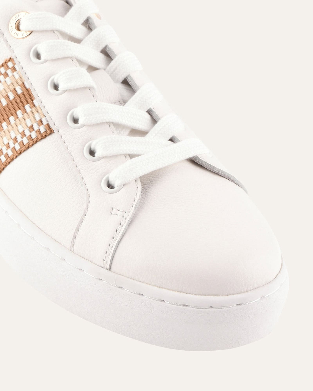 White sneaker with a gold and brown strap on a white background